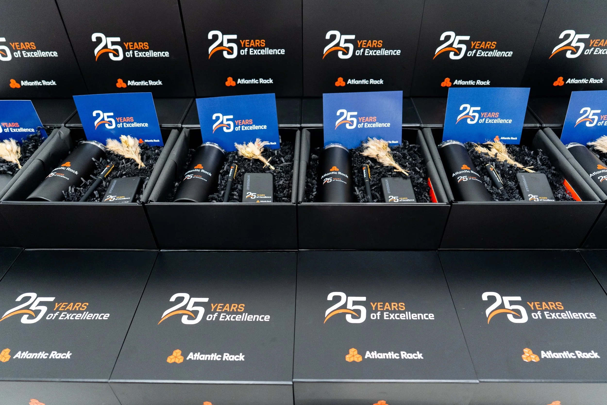 Custom company anniversary gift boxes with Atlantic Rack branded products and 25 years of excellence cards