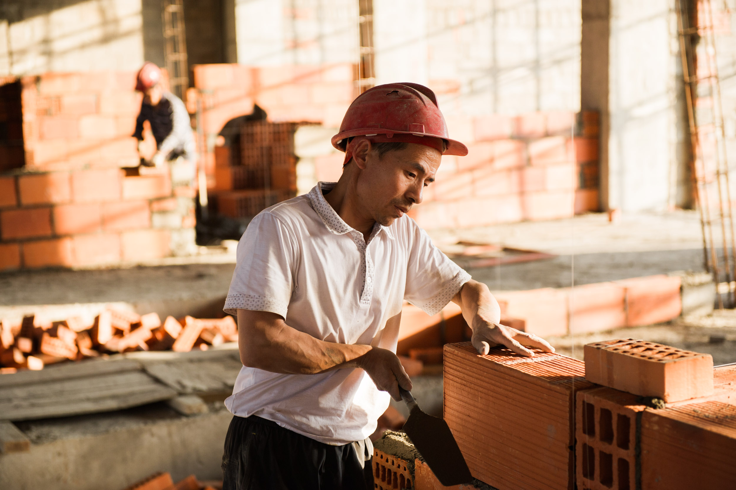  A Chinese construction worker, one of thousands of Chinese laborers in the country working on highways and buildings, at the site of the future Kigail Marriott Hotel. 