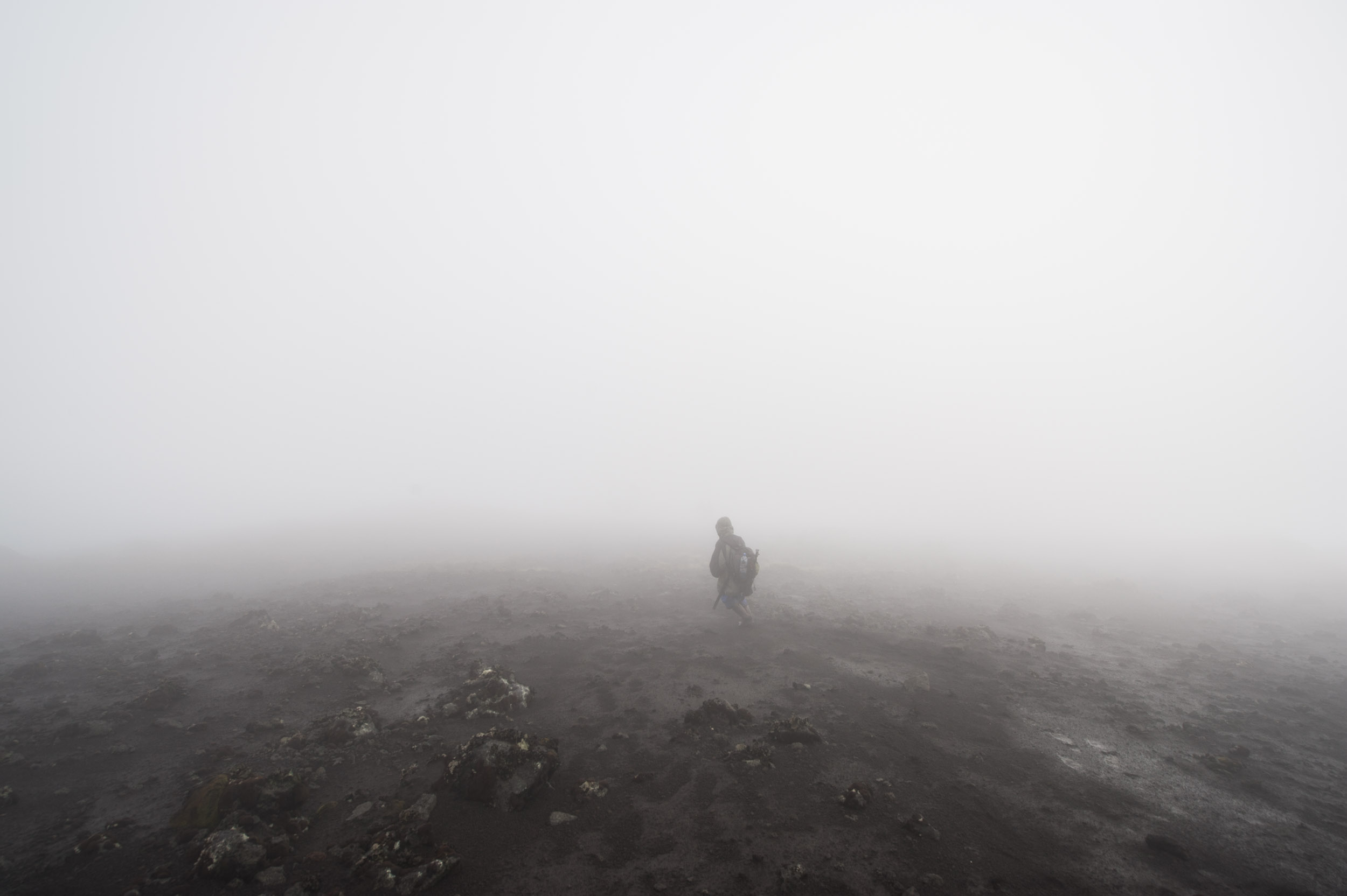  A porter walks down the summit of Mount Karisimbi, one of the Virunga volcanoes that rises over 14,400 feet tall.&nbsp; 