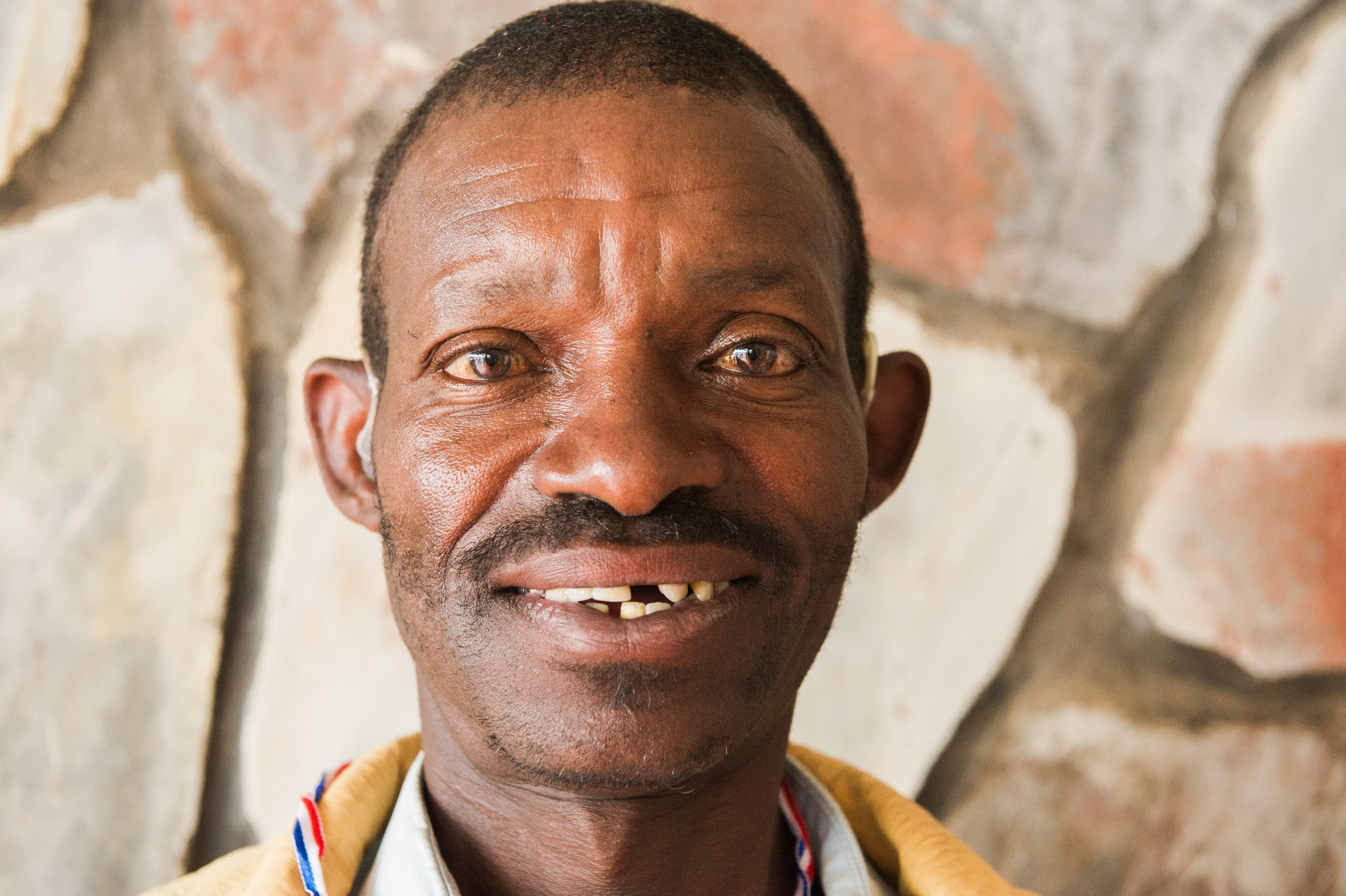  A man smiles after receiving a hearing aid. In 2011, NFL Pros for Africa (including Adrian Petersen and Larry Fitzgerald)&nbsp;and Starkey Hearing Foundation partnered to deliver more than 22,000 hearing aids to Rwandans. 