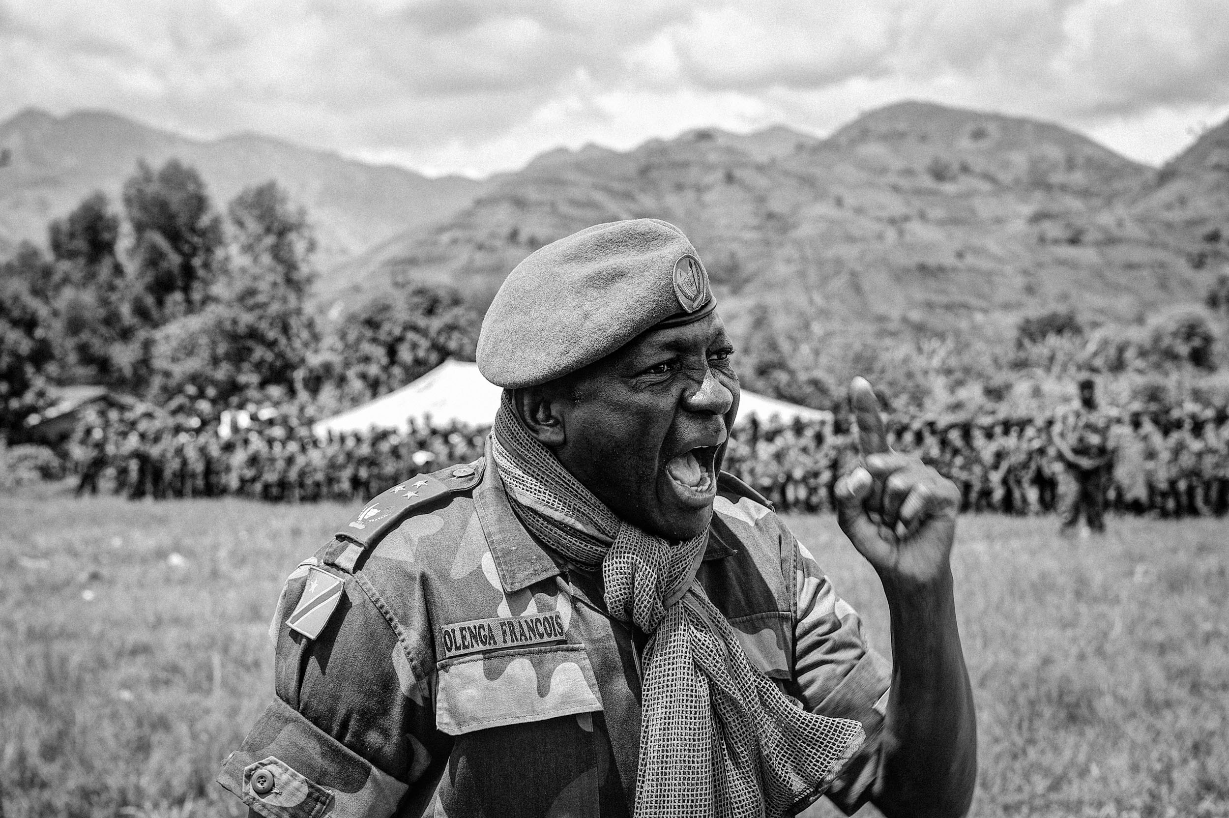  General Francois Olenga flew in a helicopter to the retreated position of his troops, the Armed Forces of the Democratic Republic of the Congo, near Lake Kivu in eastern DRC. There he led a rally, surrounded by thousands of his troops on a large fie