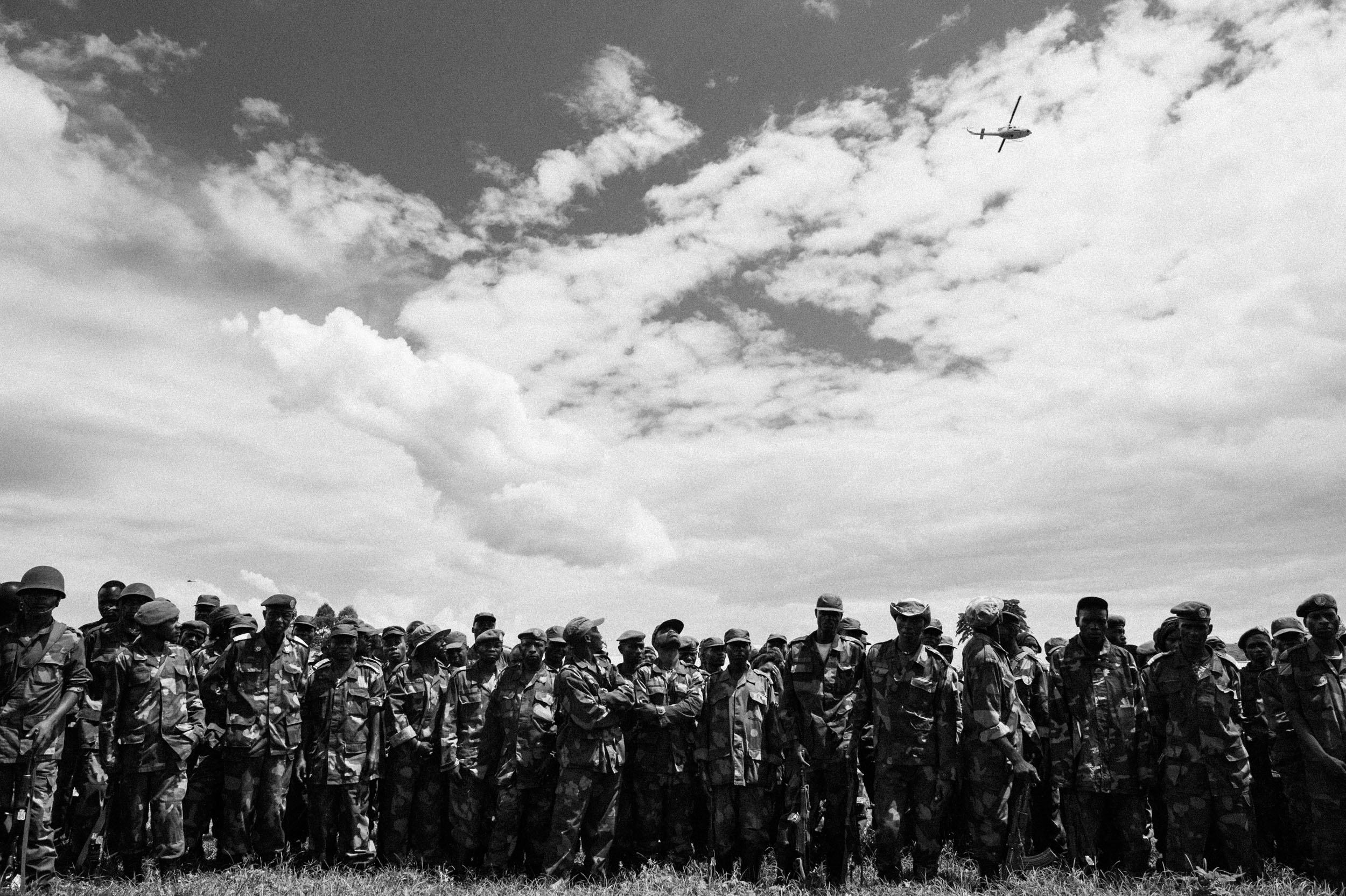  A UN helicopter passes over a group of recently retreated troops from the Armed Forces of the Democratic Republic of the Congo during the 2012 M23 Rebellion. 