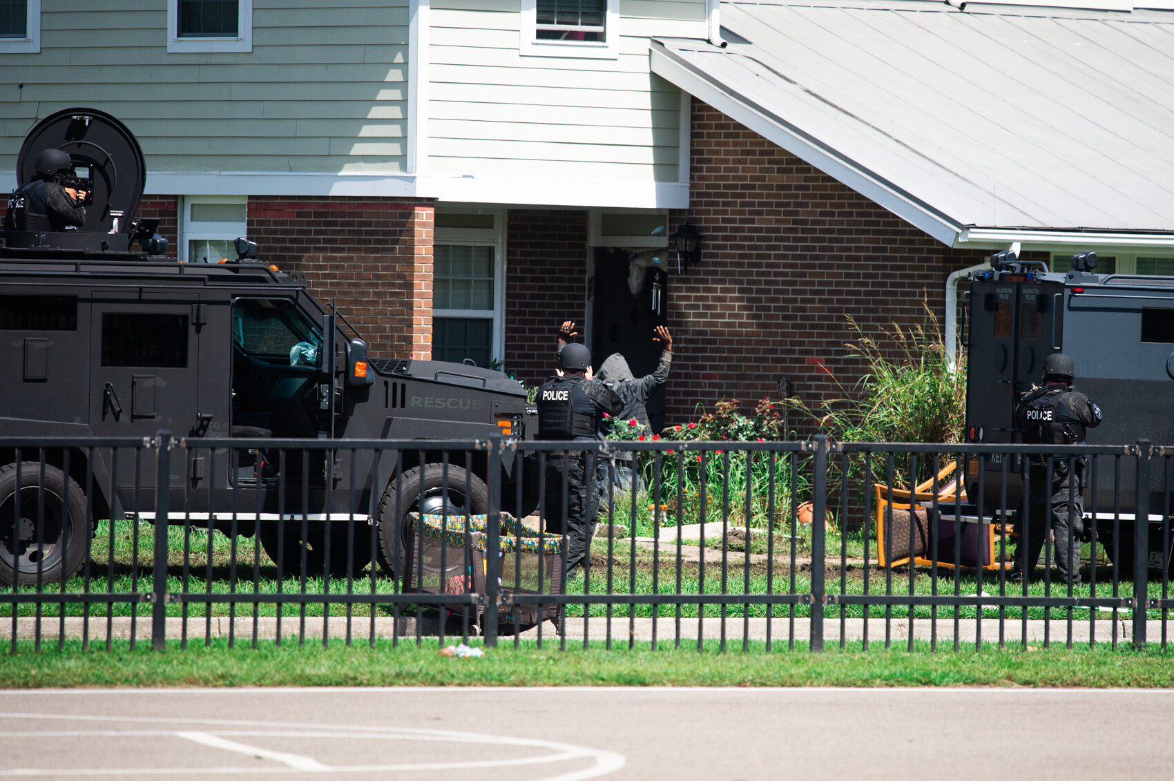  Reginald L. Wilkins kneels and raises his arms in surrender to Jacksonville Police SWAT officers as he exits a duplex in the Creekwood South community of Wilmington. (Port City Daily photo / Mark Darrough) 