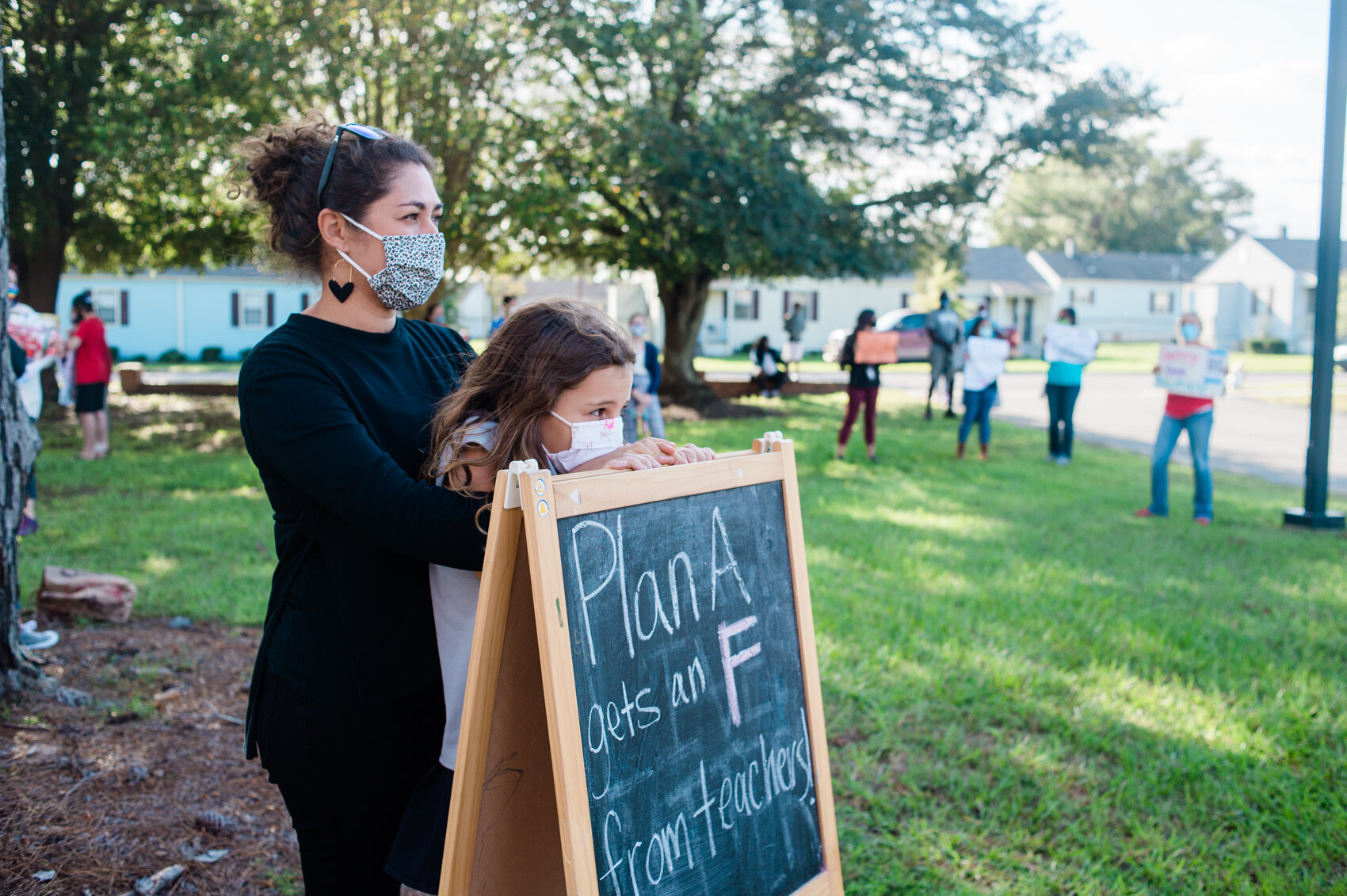  Protestors outside the New Hanover Schools Board meeting hold signs urging the district against a decision to open a full classroom model, Sep. 21, 2020. (Read the story   here  .) 