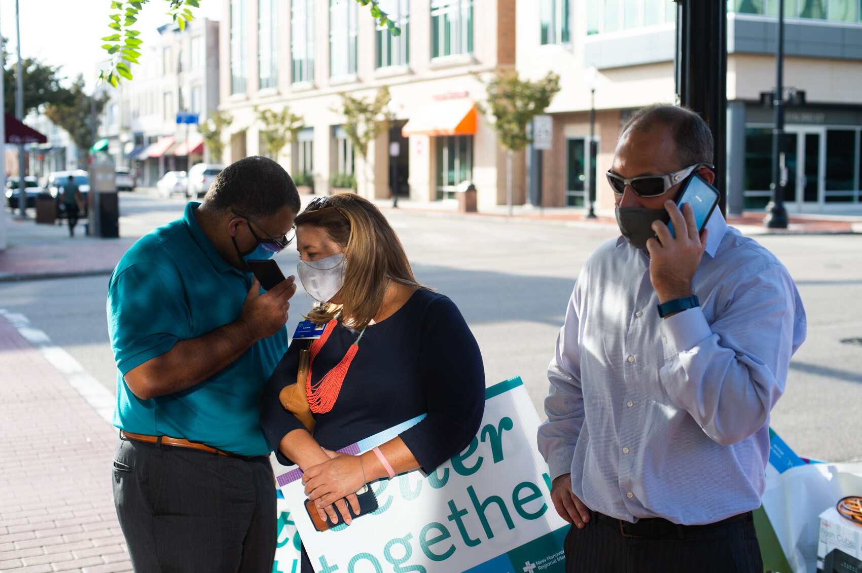  Supporters of the sale of New Hanover Regional Medical Center listen to a county commissioners’ meeting on their phones outside the county courthouse in Wilmington before commissioners voted in approval of the $1.9-billion sale. (Read the story  her