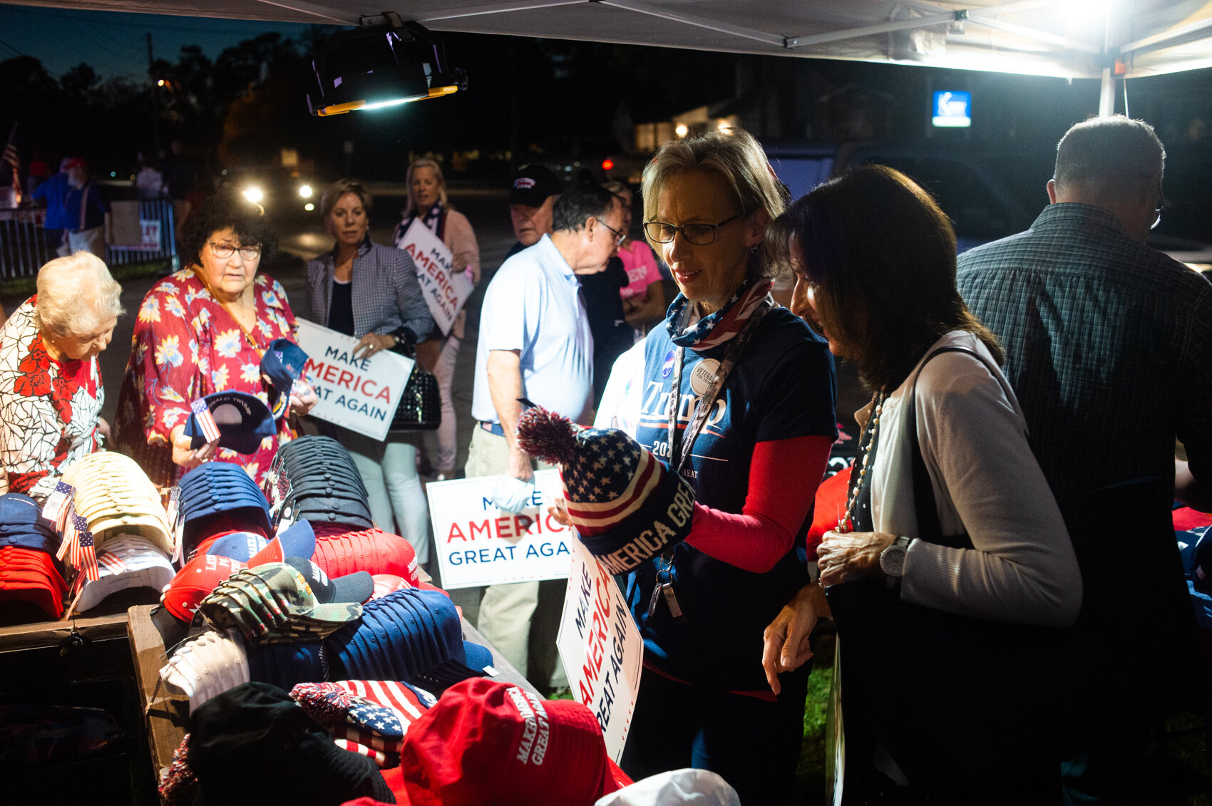 Women look at a Make America Great winter hat in a tent set up outside the New Hanover GOP building on Market Street. (Port City Daily photo/Mark Darrough) 