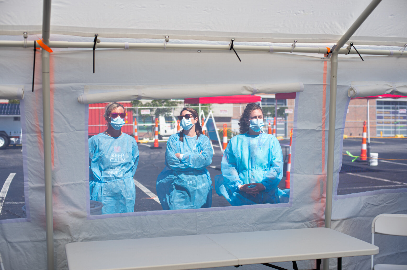 Public health nurses stand outside a drive-through tent where they will be administering nasal swabs for New Hanover County residents experiencing symptoms of Covid-19. (Port City Daily photo/Mark Darrough) 