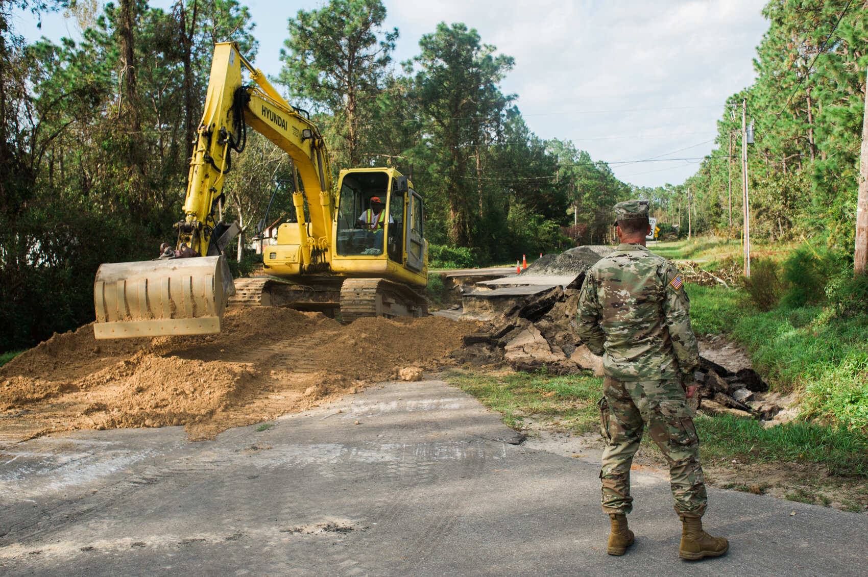  First Sergeant Andrew McNulty oversees a contracted excavator filling in a washout on Boiling Springs Lake Road in the town of Boiling Springs Lake, days after Hurricane Florence broke a damn in the small coastal town. (Port City Daily photo | Mark 