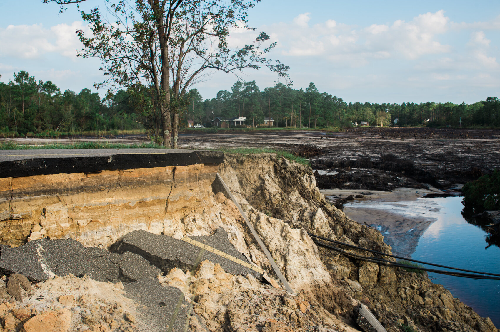  One of the large washouts on Boiling Spring Lakes Road, the now empty Patricia Lake in the background, Sunday morning, September 22, 2018. The washout occurred after the lake’s dam was breached by Hurricane Florence. 