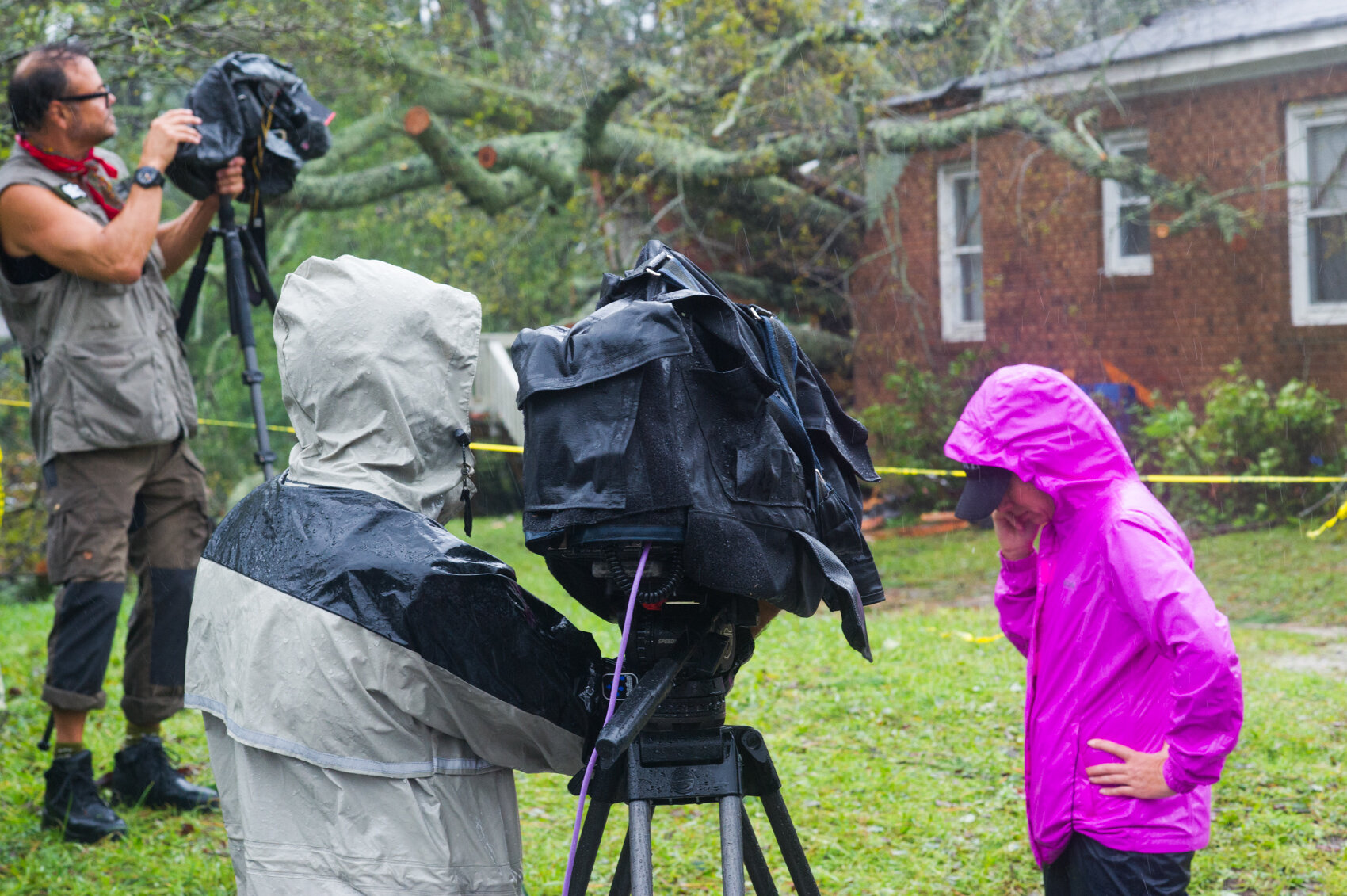  A mother and her infant child were killed Friday morning when a large tree, pictured, fell onto their house on Mercer Avenue, marking the first confirmed fatalities of Hurricane Florence in Wilmington. Television crews prepare to shoot footage of th