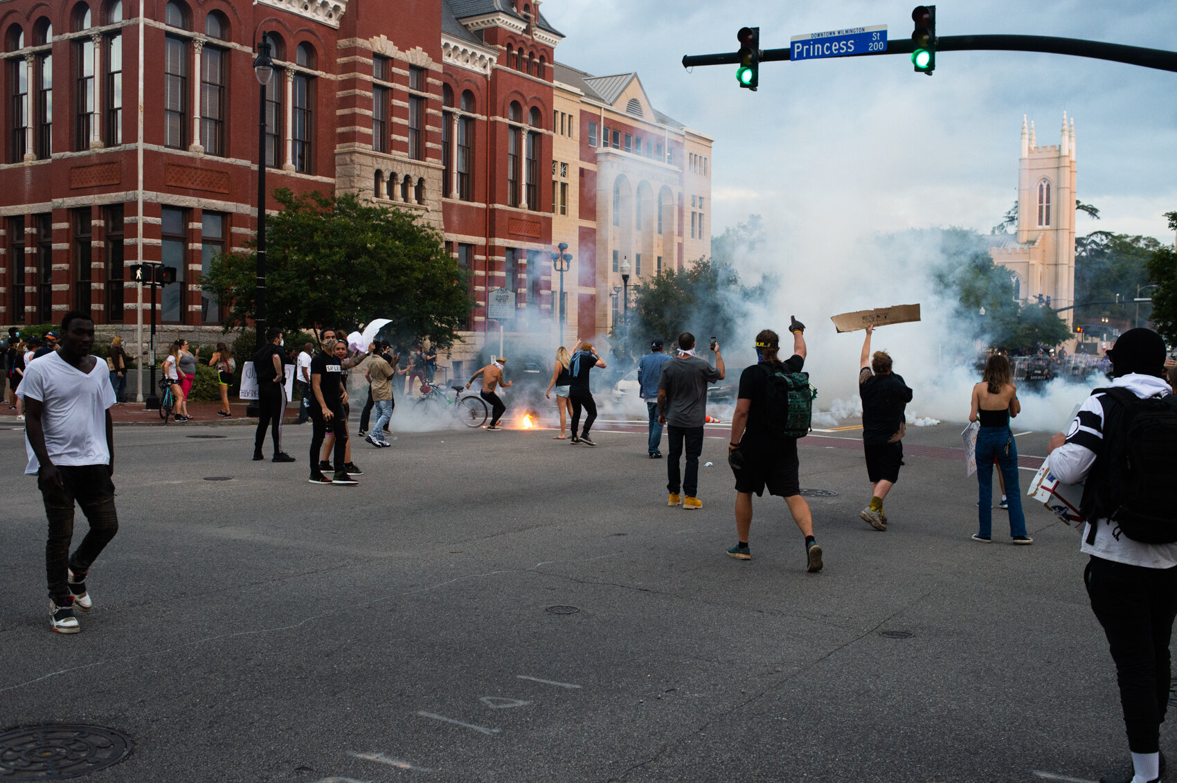  A protestor attempts to put out a fire where a tear gas canister struck the street, May 30, 2020. Most of the crowd of protestors outside City Hall had dispersed after the first volley of tear gas canisters fired by the deputies. (Read the story  he