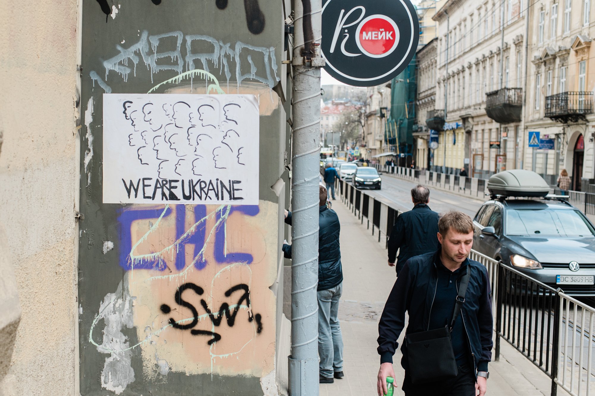  A man walks by a poster that reads "We are Ukraine" near the Lviv National Art Gallery. (April 15, 2022) 