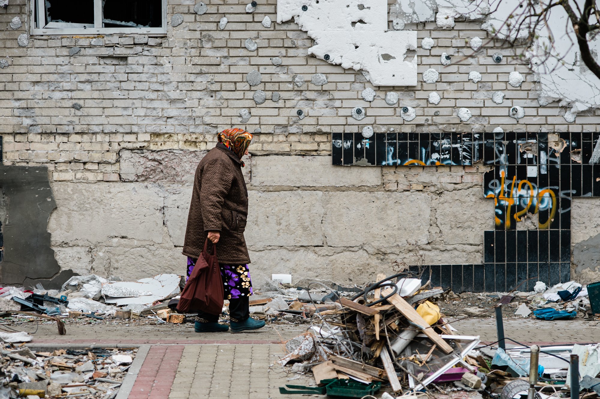  A woman walks by a building damaged by Russian artillery in Irpin, a suburb of Kyiv. 