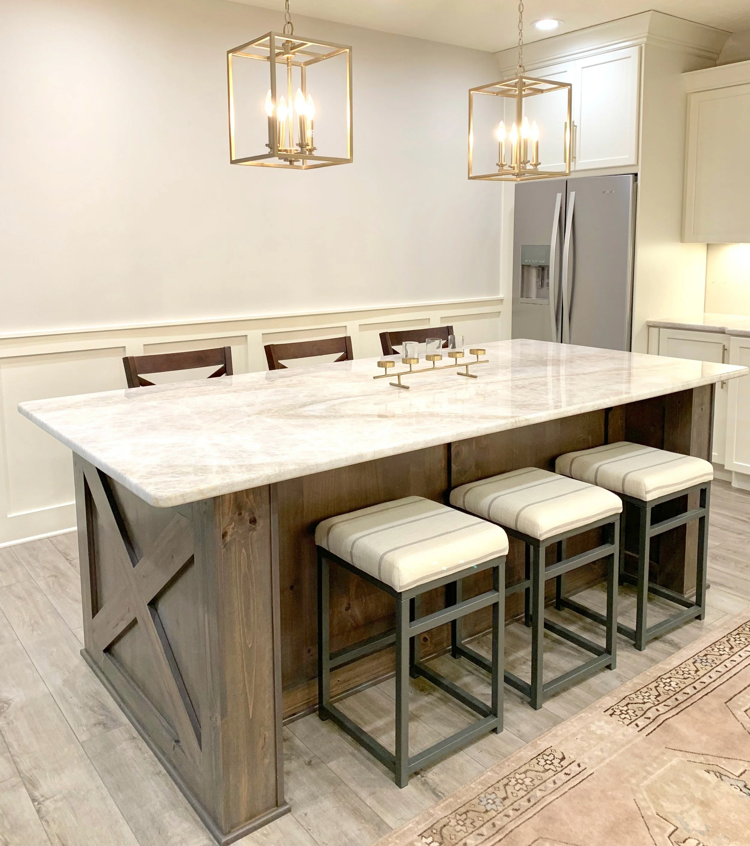 Modern farmhouse kitchen with white and wood cabinets, matte brass lights and vintage rug. Farmhouse Redefined.