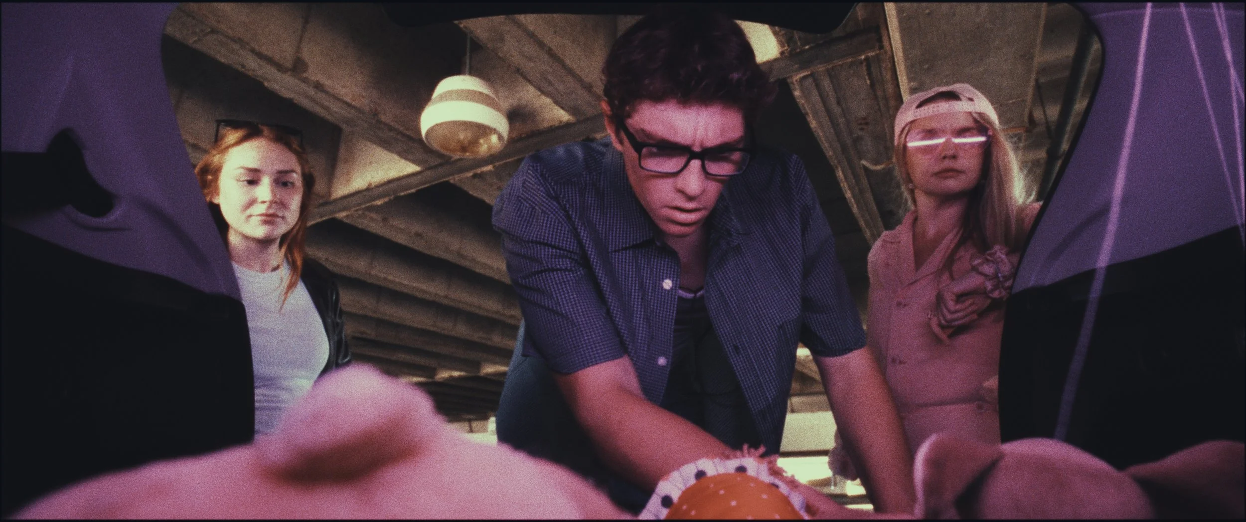 Low-angle shot of three people looking down toward the camera, still from Five Finger Stakeout (2026), shot in Omaha, Nebraska by cinematographer Cole Mowery