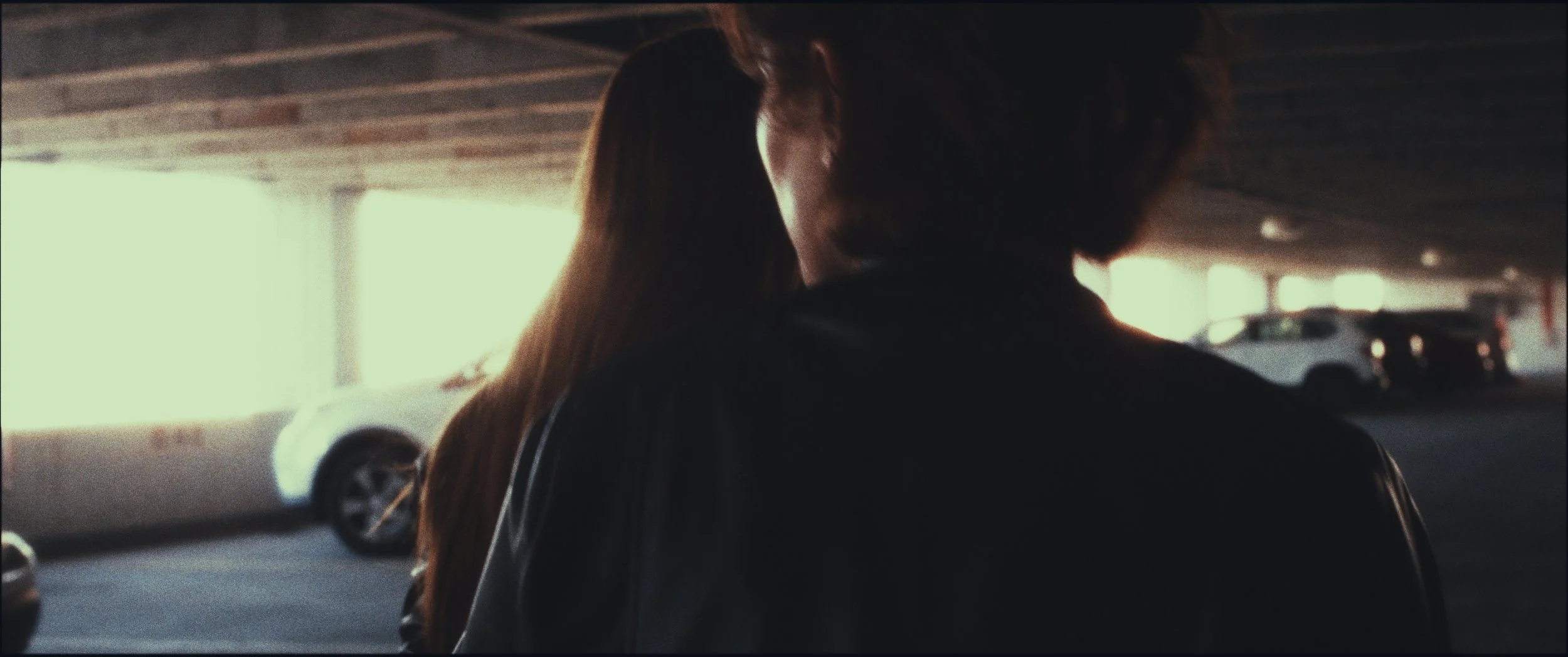 Two people embracing in a parking garage, seen from behind, Five Finger Stakeout, Omaha 48 Hour Film Challenge 2026