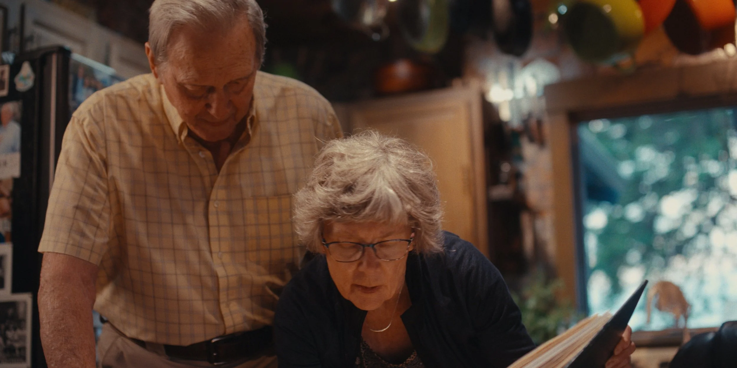 Older farming couple looking over papers together in their kitchen, still from a Folsom Lake Solar commercial shot in Mills County, Iowa by director of photography Cole Mowery