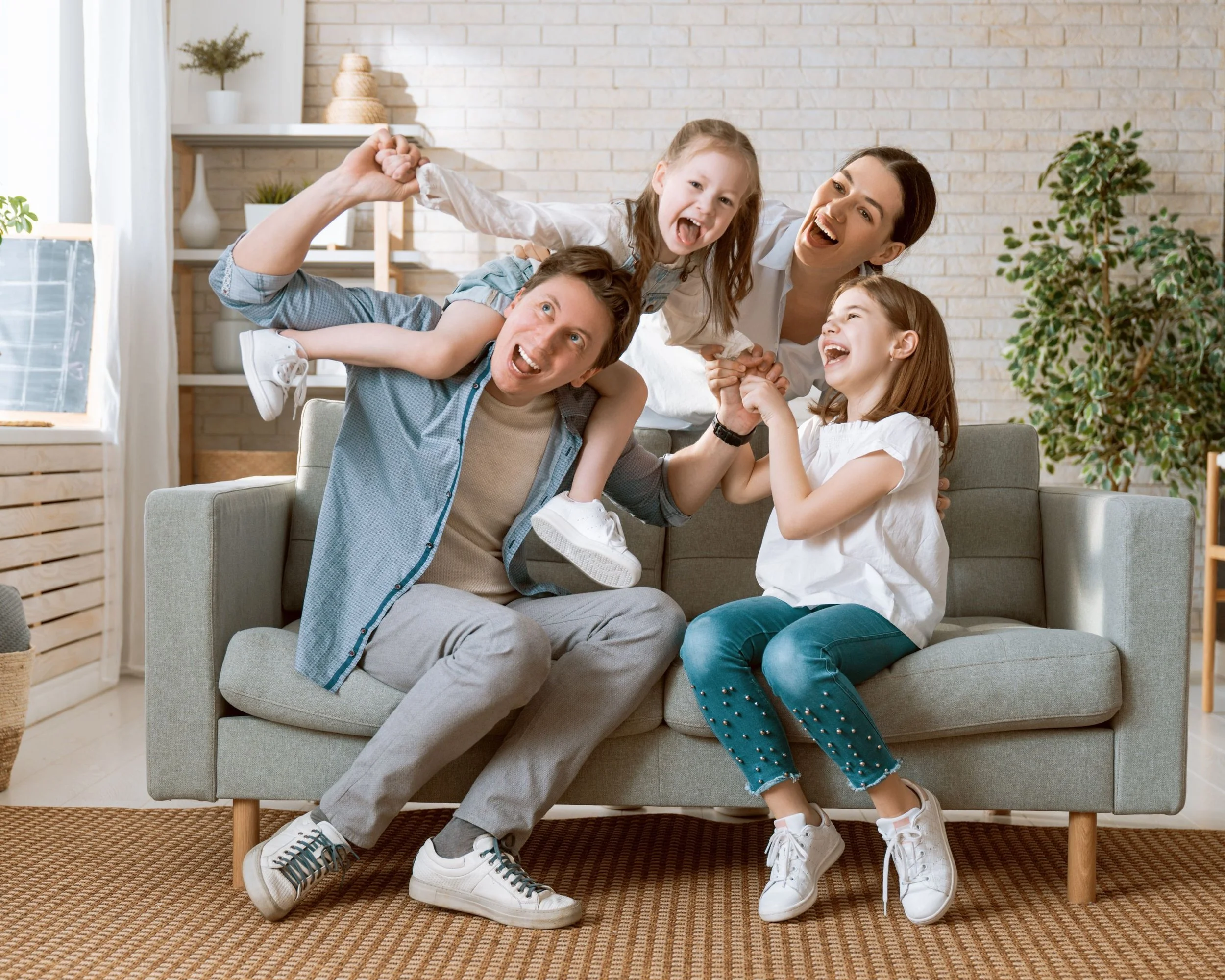 Famiglia felice che gioca sulla poltrona nel soggiorno.