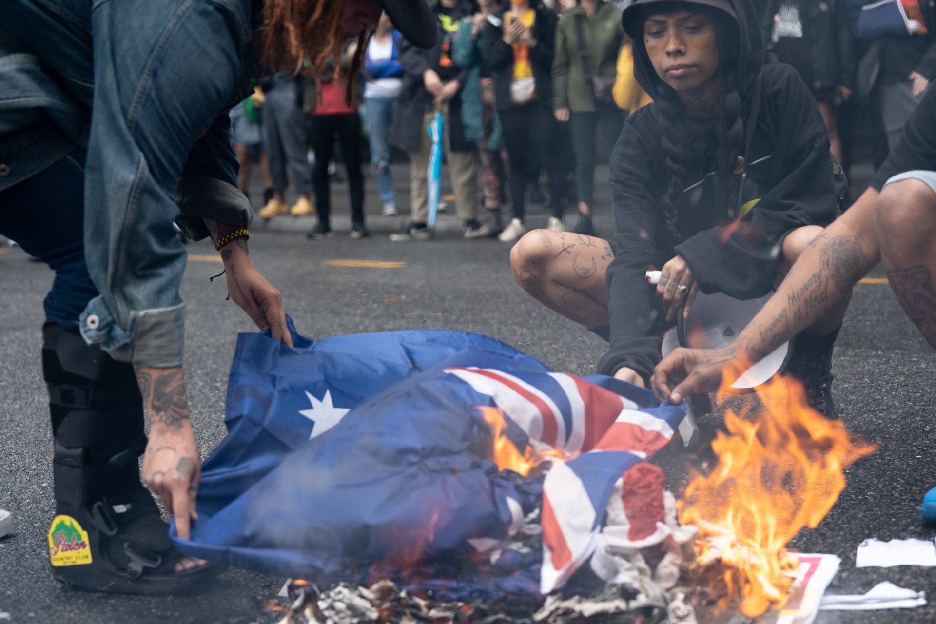 Brisbane Warriors of the Aboriginal Resistance burn an Australian flag during their demonstration against continued racial colonial imperialism on the public holiday given to mourn the death of the late Queen Elizabeth II. September 22, 2022.  
