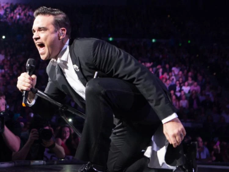 Robbie Williams performing to celebrate the career of legendary jockey AP McCoy