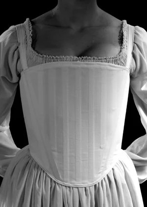 tudor corset dress Inspired by the formidable presence of Queen Elizabeth Tudor, this gown  exudes both power and allure. The structured corset, sheer with exposed  boning, evokes a raw, modern feminine grace, while its grand
