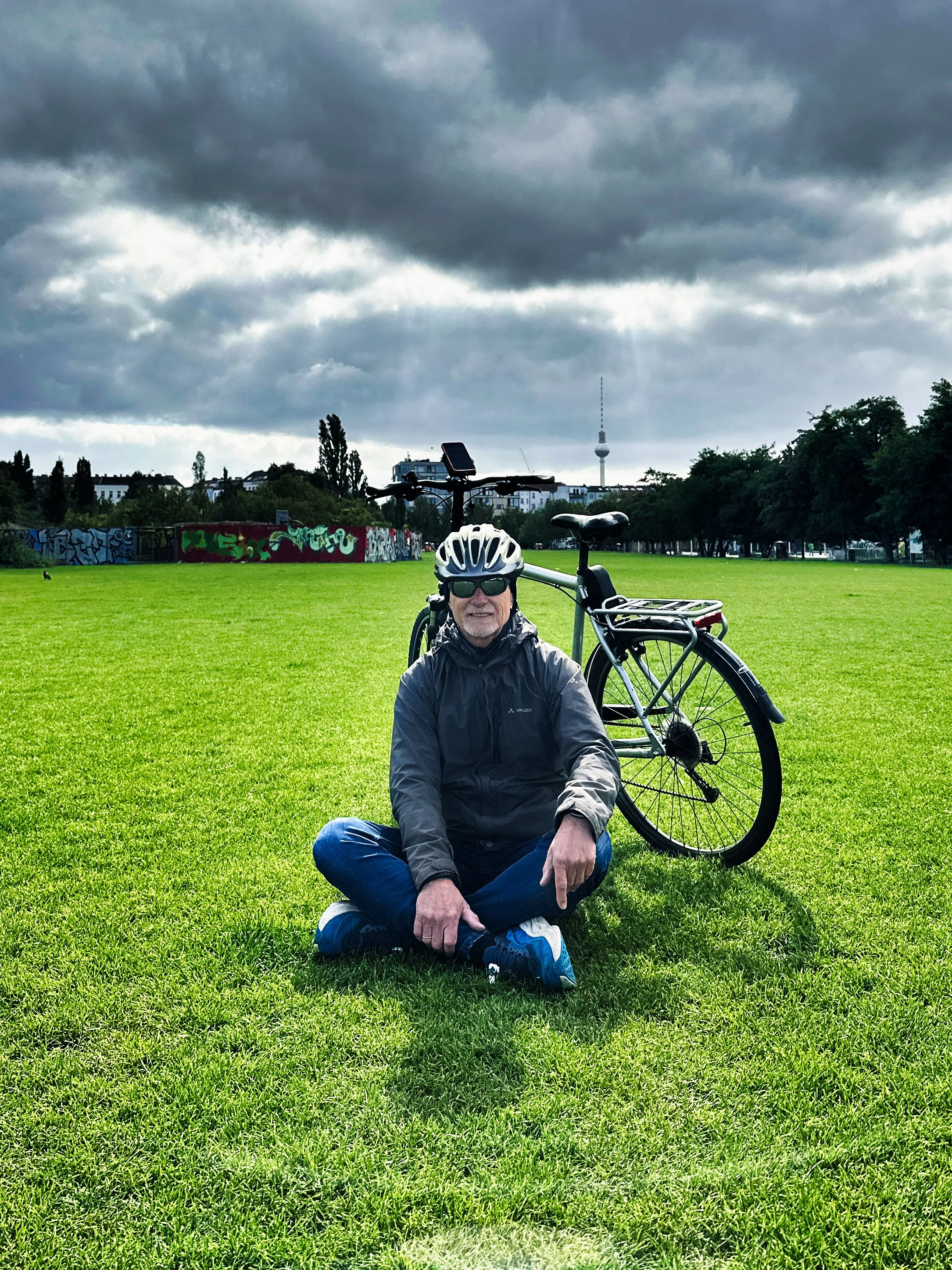 Berliner Bezirke mit dem Fahrrad erkunden, Mann auf einem Rasen mit Fahrrad