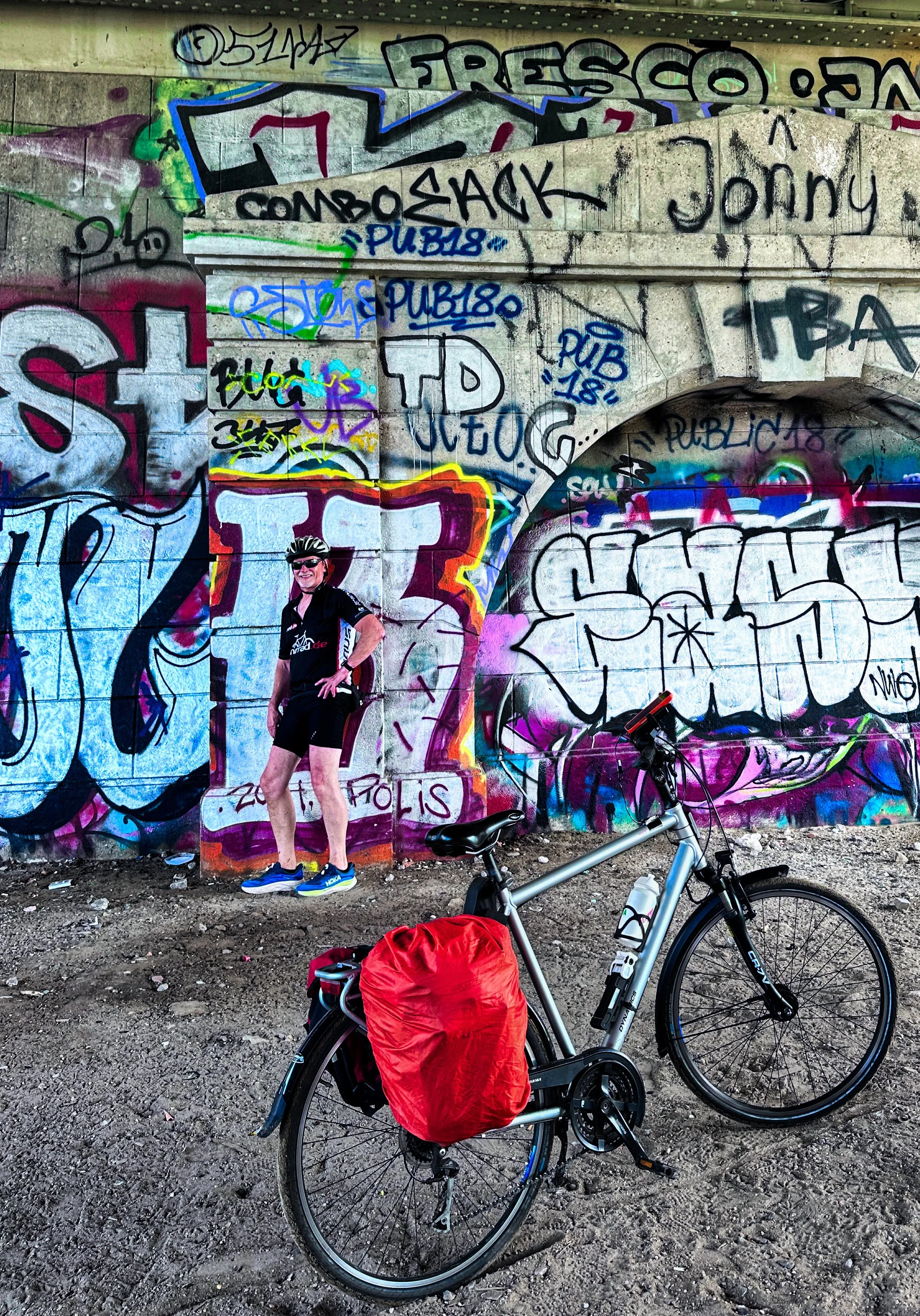 Berliner Mauerweg, Graffiti-Kunst unter einer Brücke mir Mann und Fahrrad