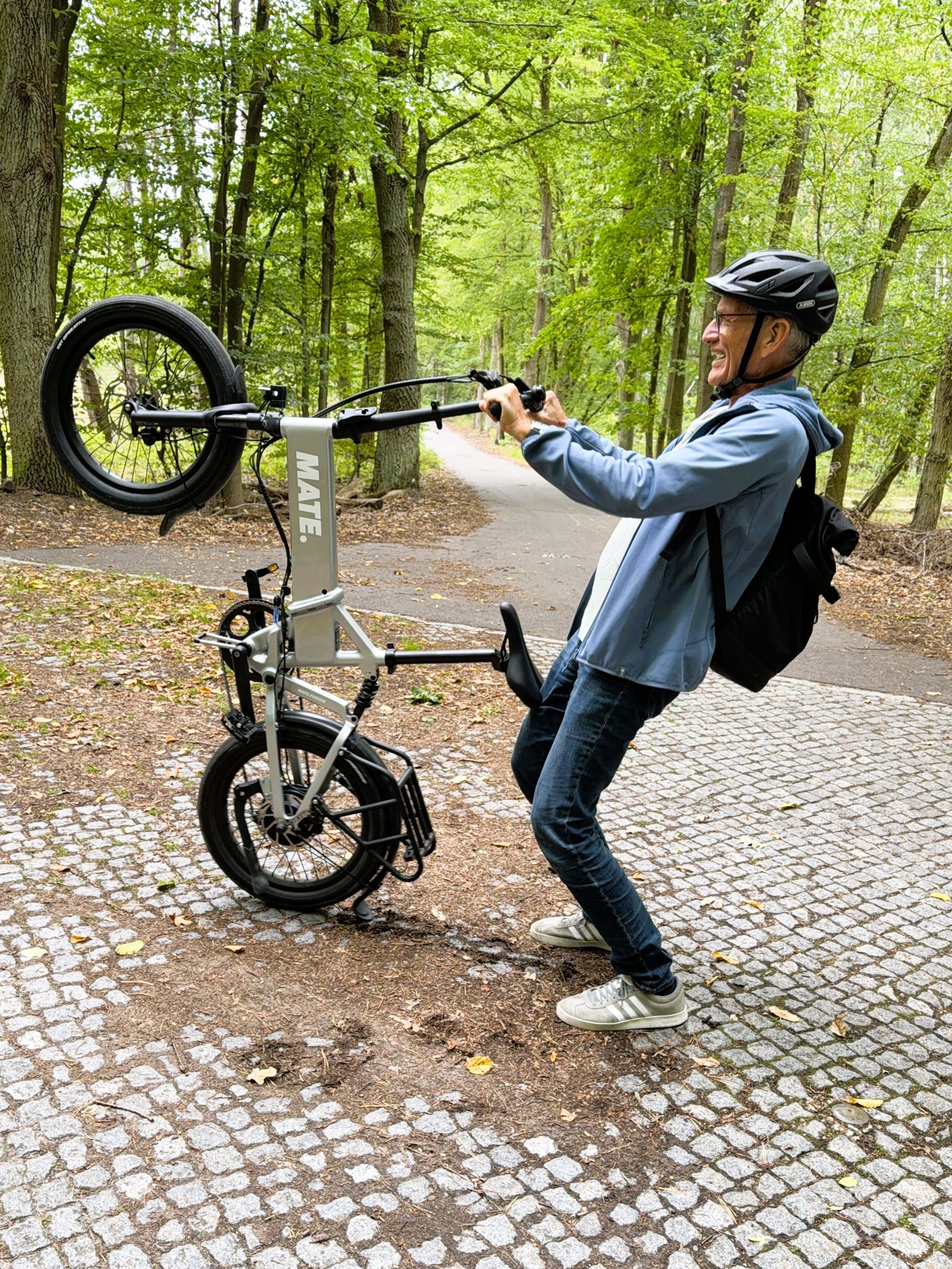 Genießen statt anstrengen – E-Bike-Test, Mann mit Faltrad es vorn hochhebend