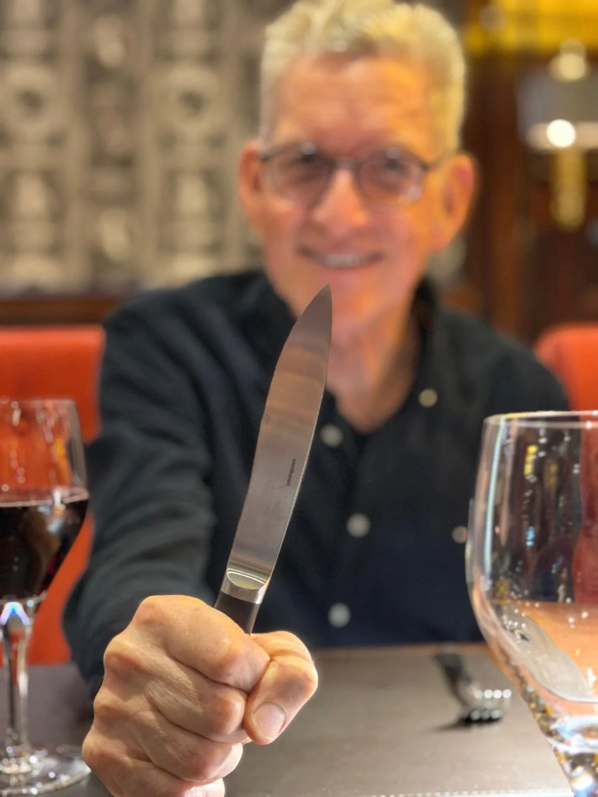 Mann mit hochgehaltenem Steak-Messer -Morgenpost-Menü März 2026 - JW Steakhouse