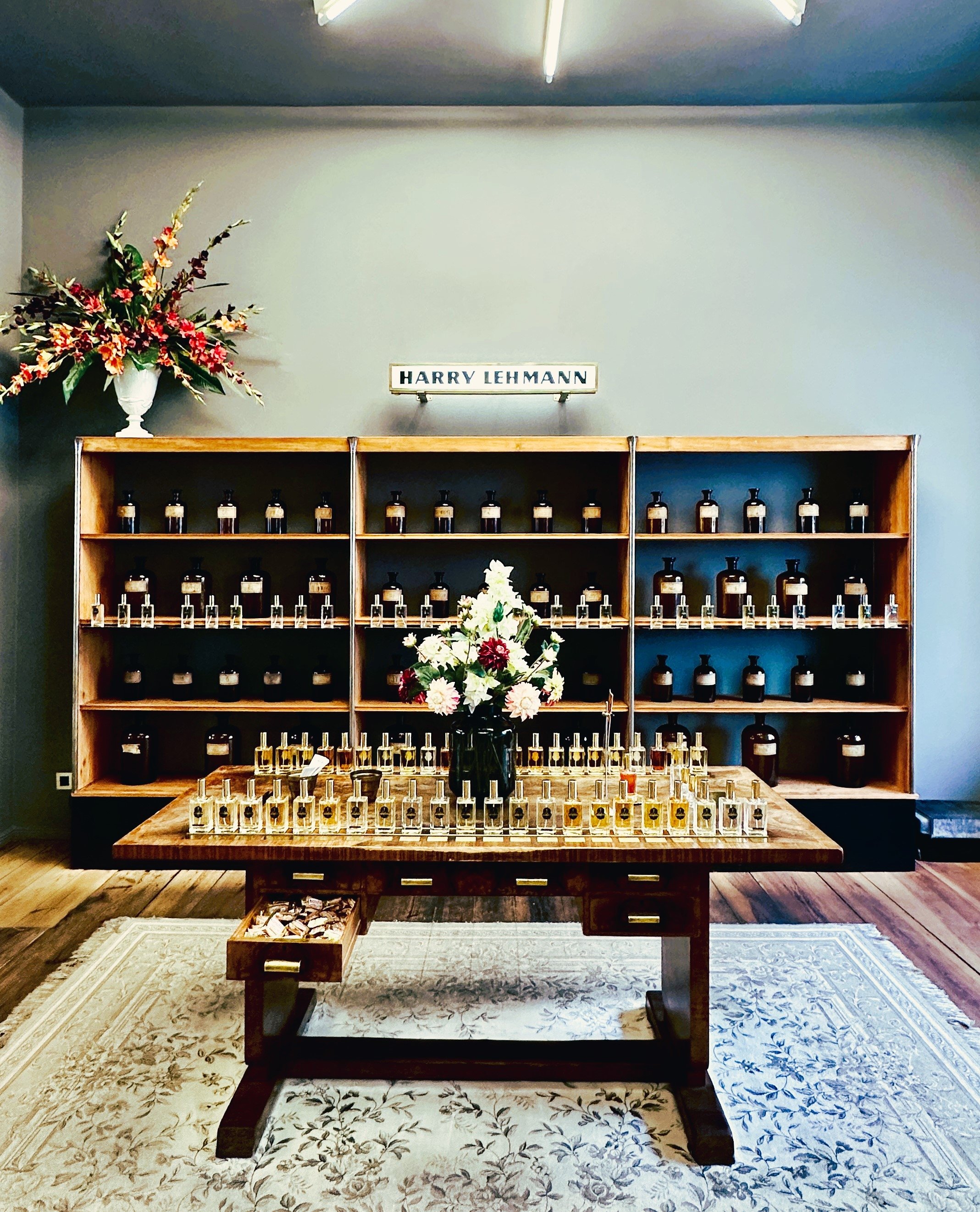 Mein Parfum von Harry Lehmann, ein Raum mit Regal, Blumen und Parfümflakons