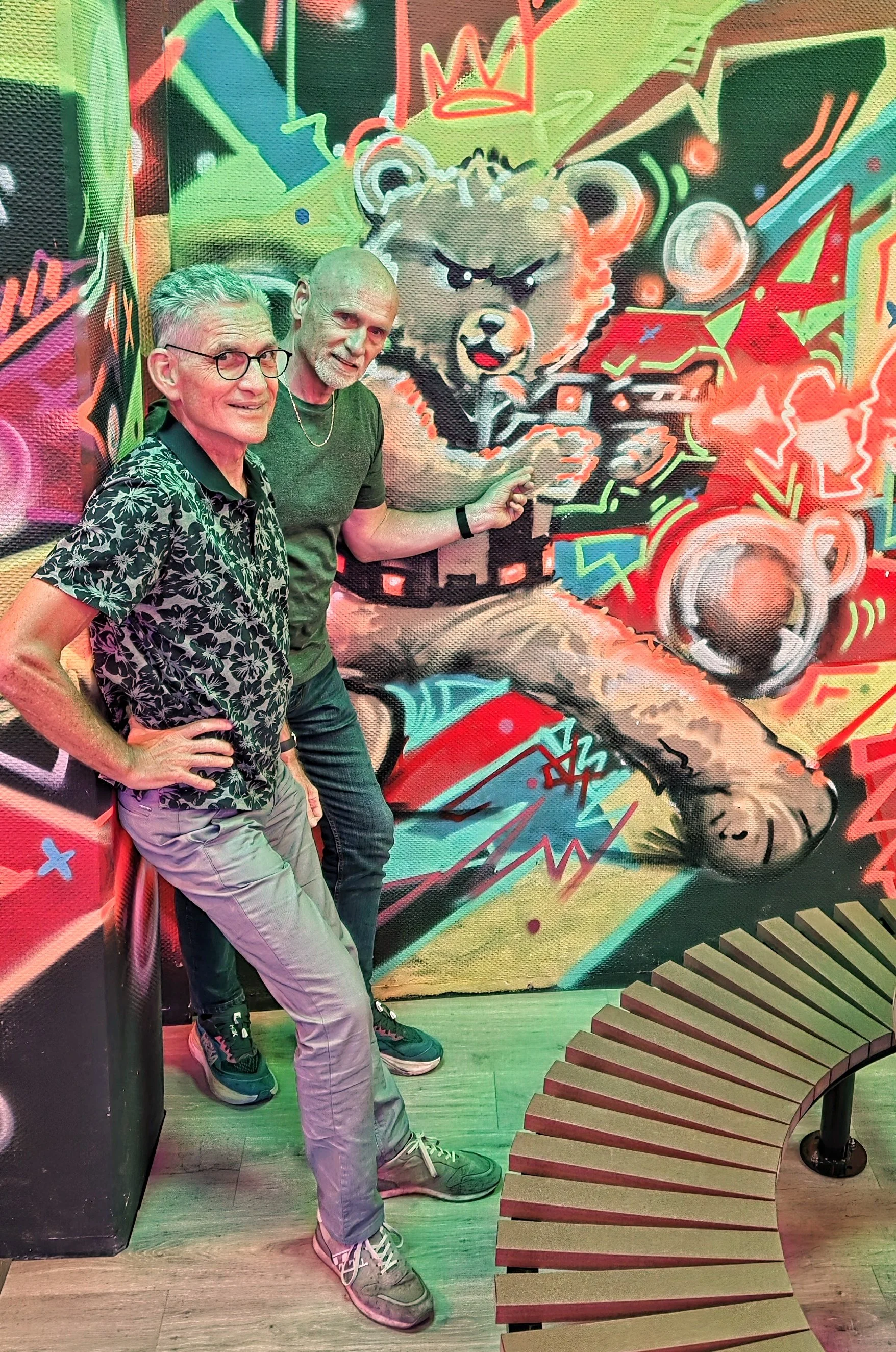 Laser4-Tag Bewertung-lohnt-es-sich? - zwei Männer vor einer bunten Wand mit Bär