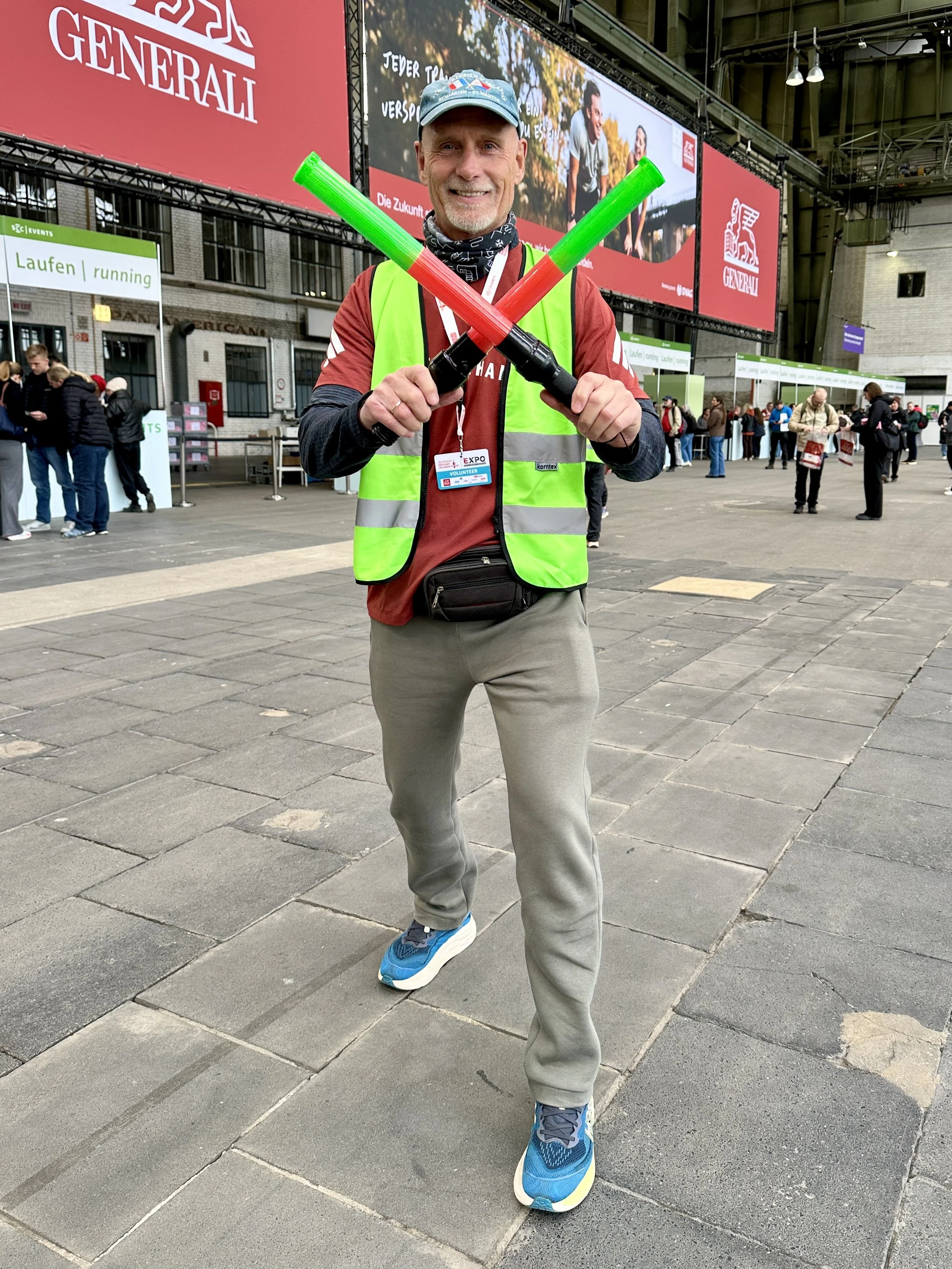 Ehrenamt für Senioren Berlin, Volunteer-Einsatz auf der Expo Halbmarathon 2026, ein Mann mit 2 Leuchtstäben, gekreuzt