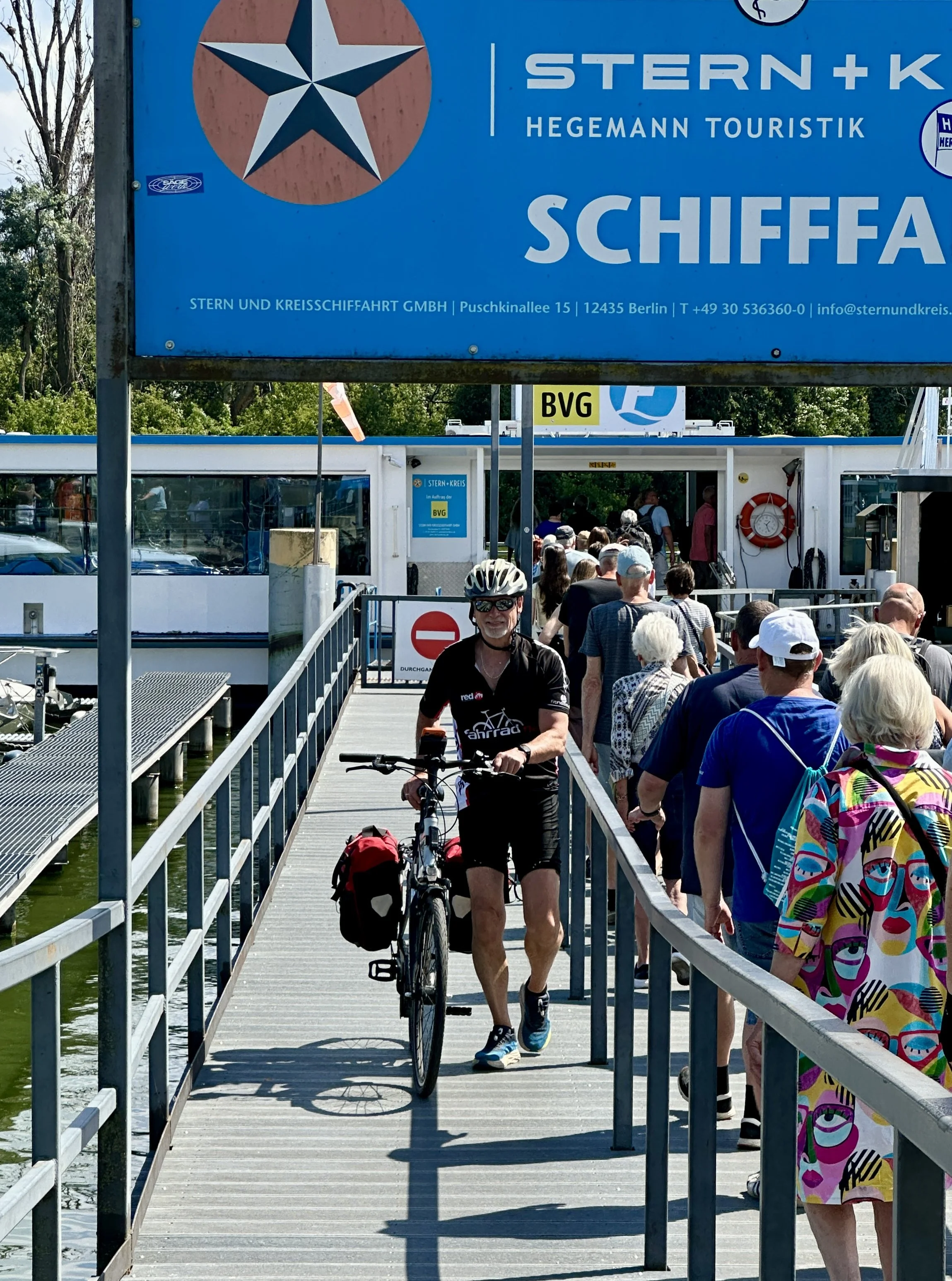 Berliner Mauerweg mit dem Fahrrad, Mann verlässt eine Fähre mit Fahrrad