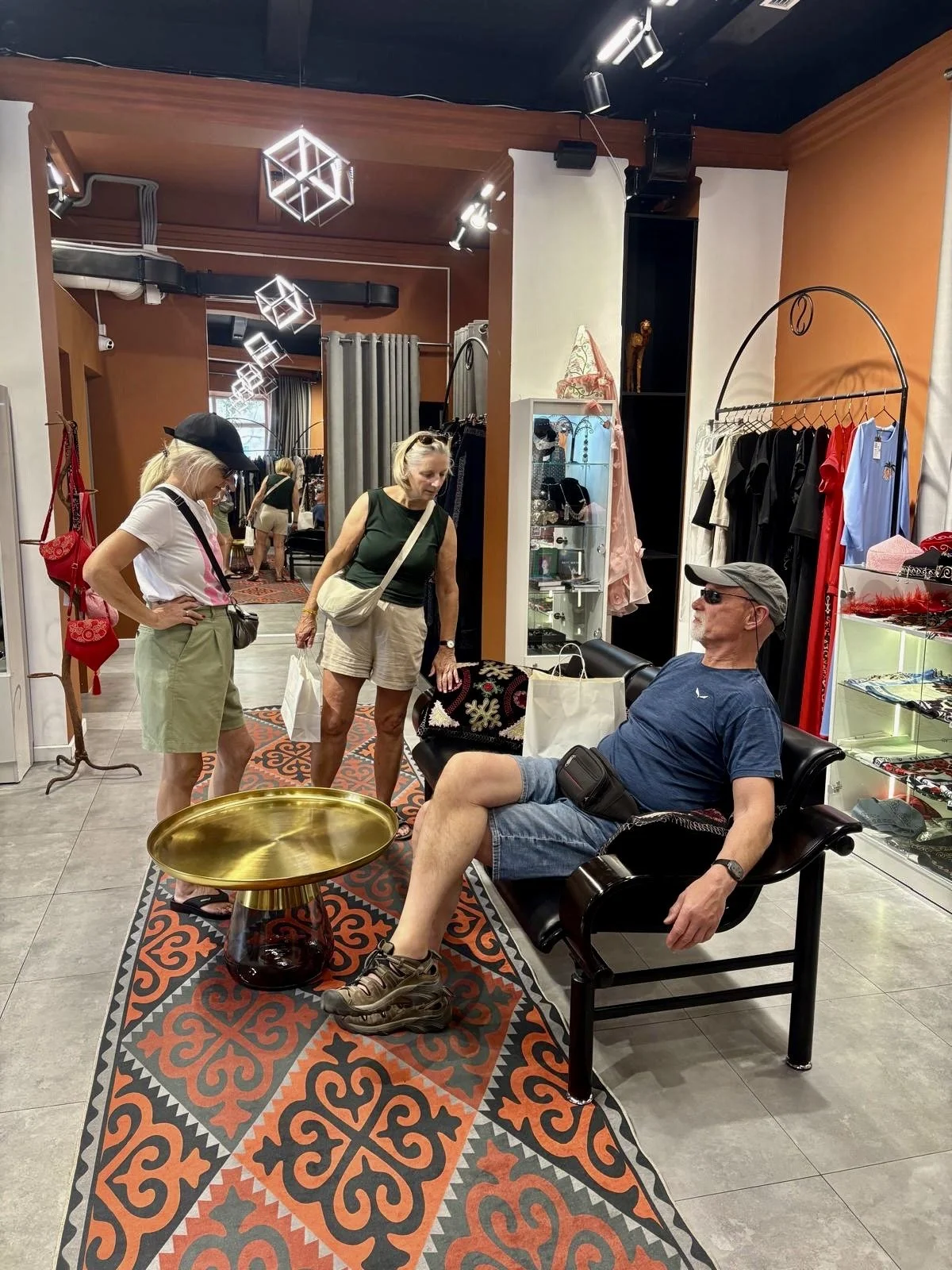 Kirgistan Reisebericht, in einem Shop in Bishkek, Mann auf dem Sofa, zwei Frauen in der Nähe