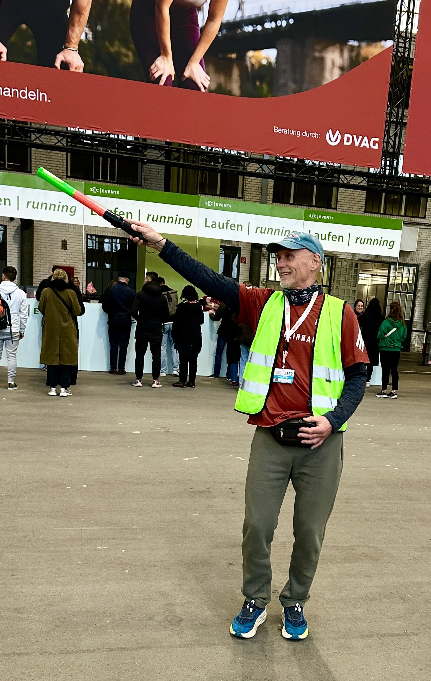 Ehrenamt für Senioren Berlin, Volunteer-Einsatz auf der EXPO Halbmarathon 2026, Mann mit Leuchtstab in eine Richtung zeigend
