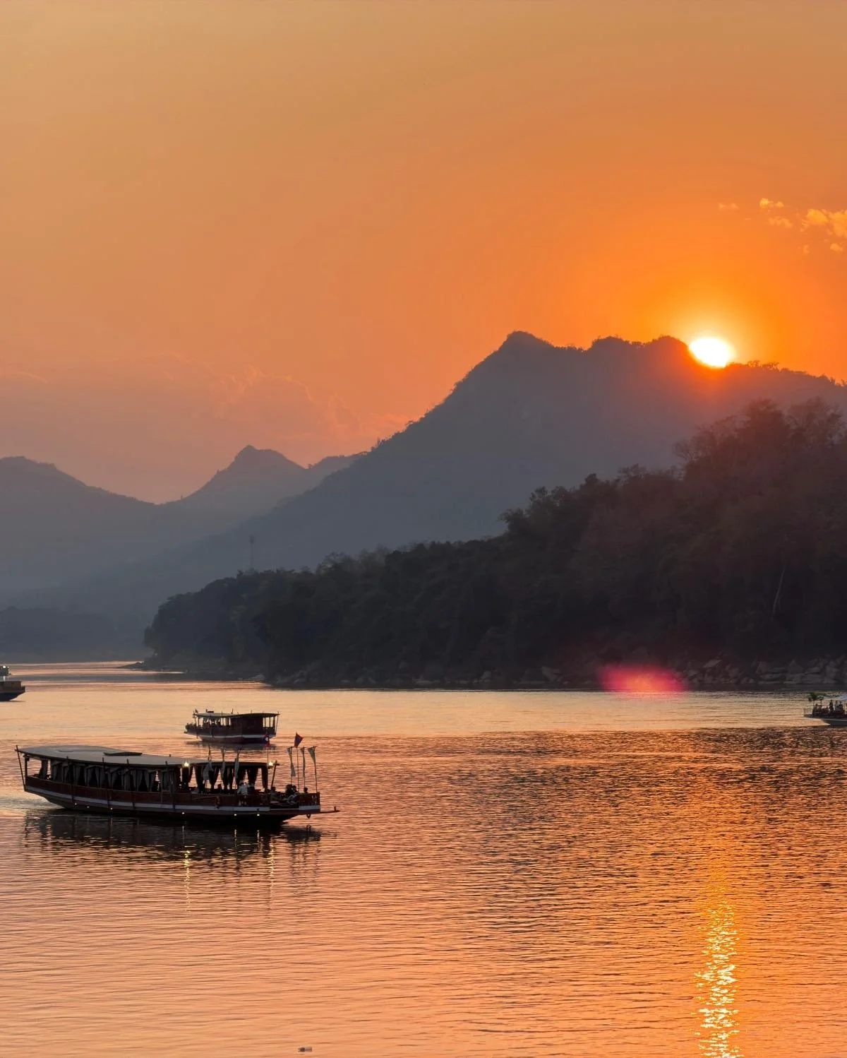 Laos - Rundreise auf eigene Faust - Sonnenuntergang hinter Karstbergen am Mekong in Luang Prabang