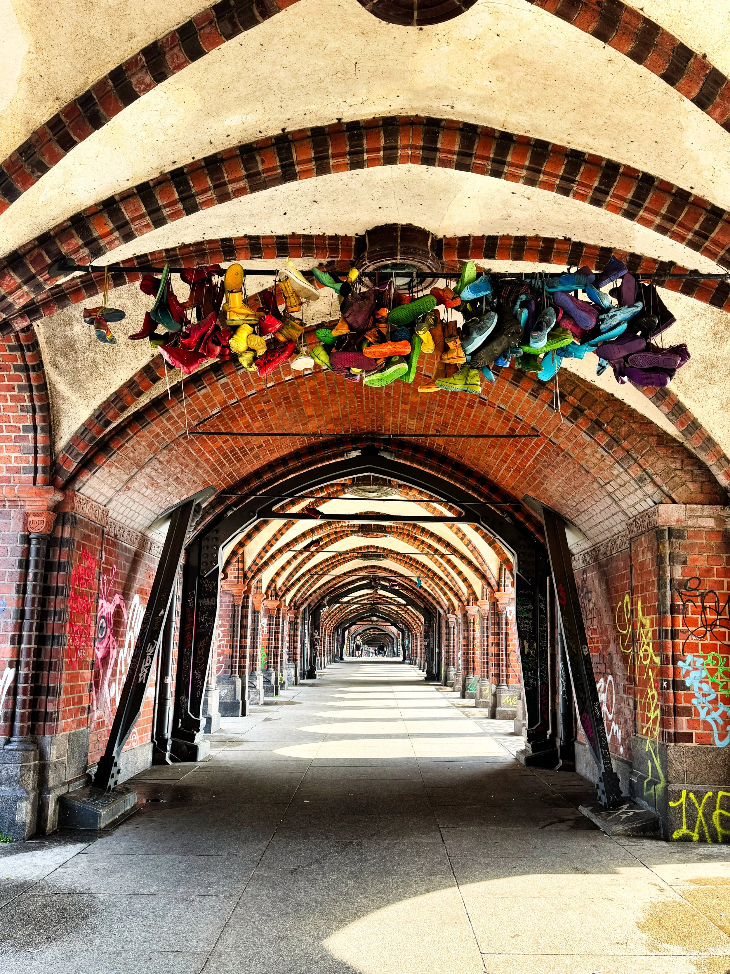 Berliner Mauerweg mit dem Fahrrad, Schuhe hängend unter den Bögen der Oberbaumbrücke