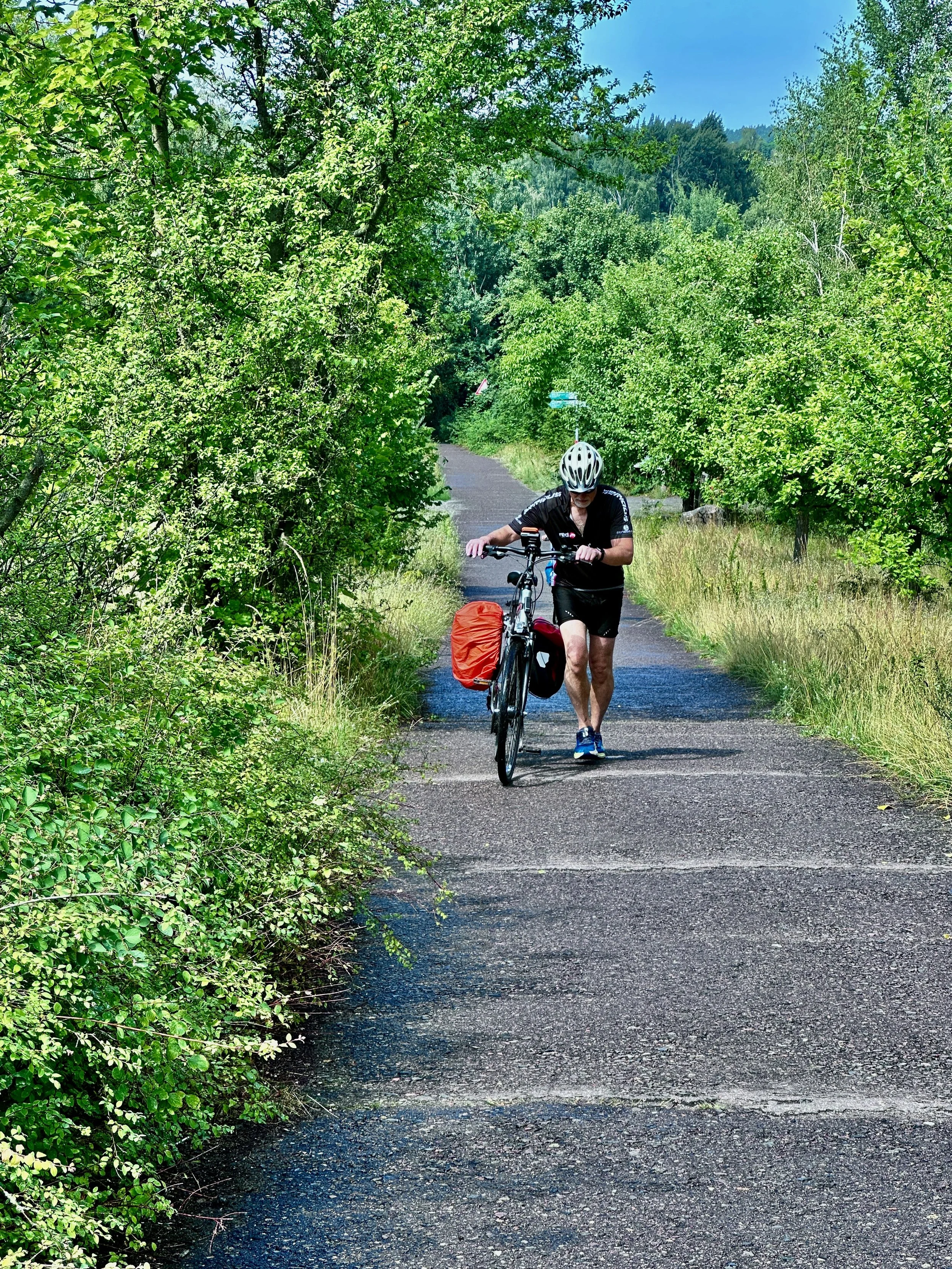 Berliner Mauerweg mit dem Fahrrad, Mann Fahrrad schiebend auf Weg