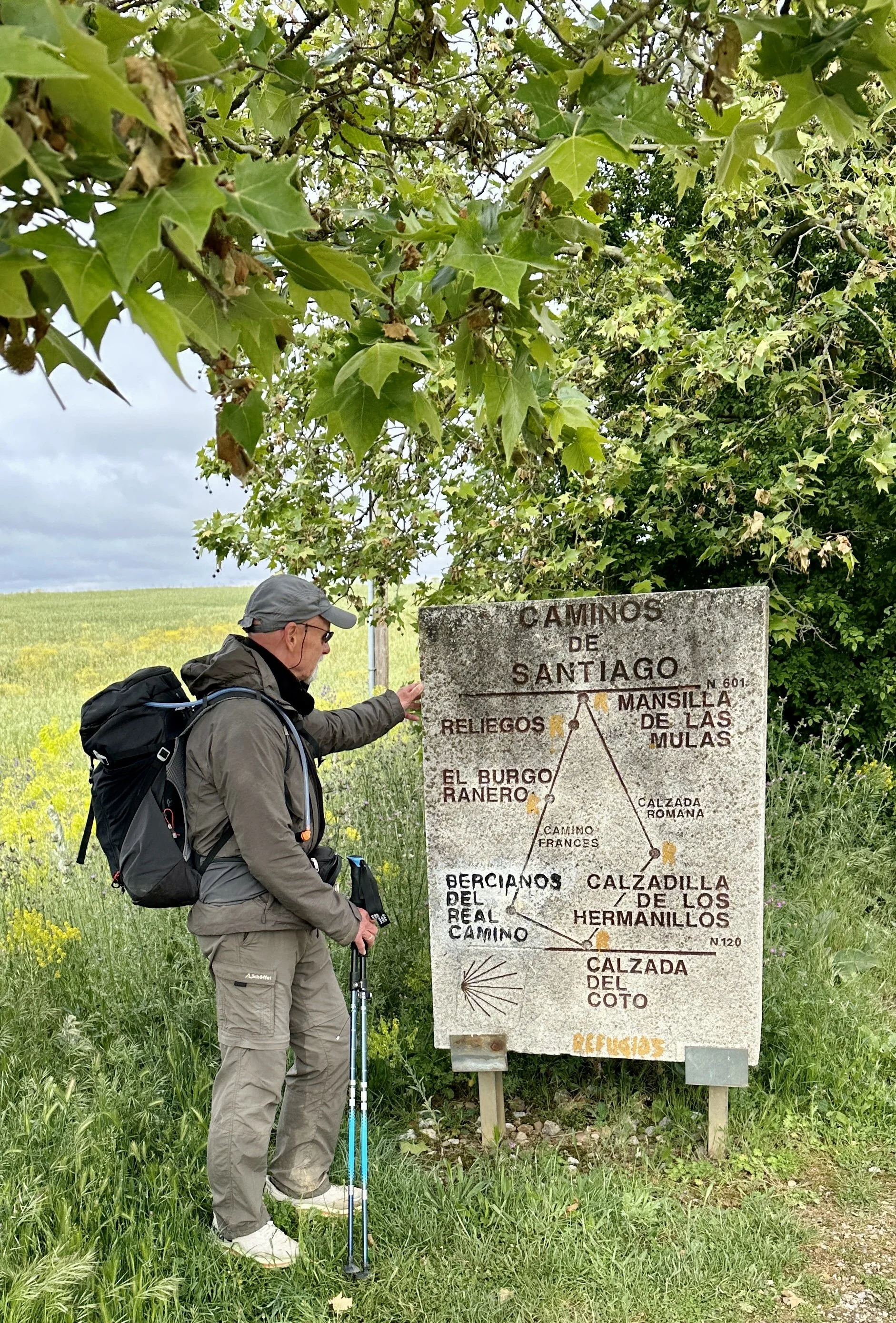 Camino Francés, Mann vor Tafel mit Rucksack