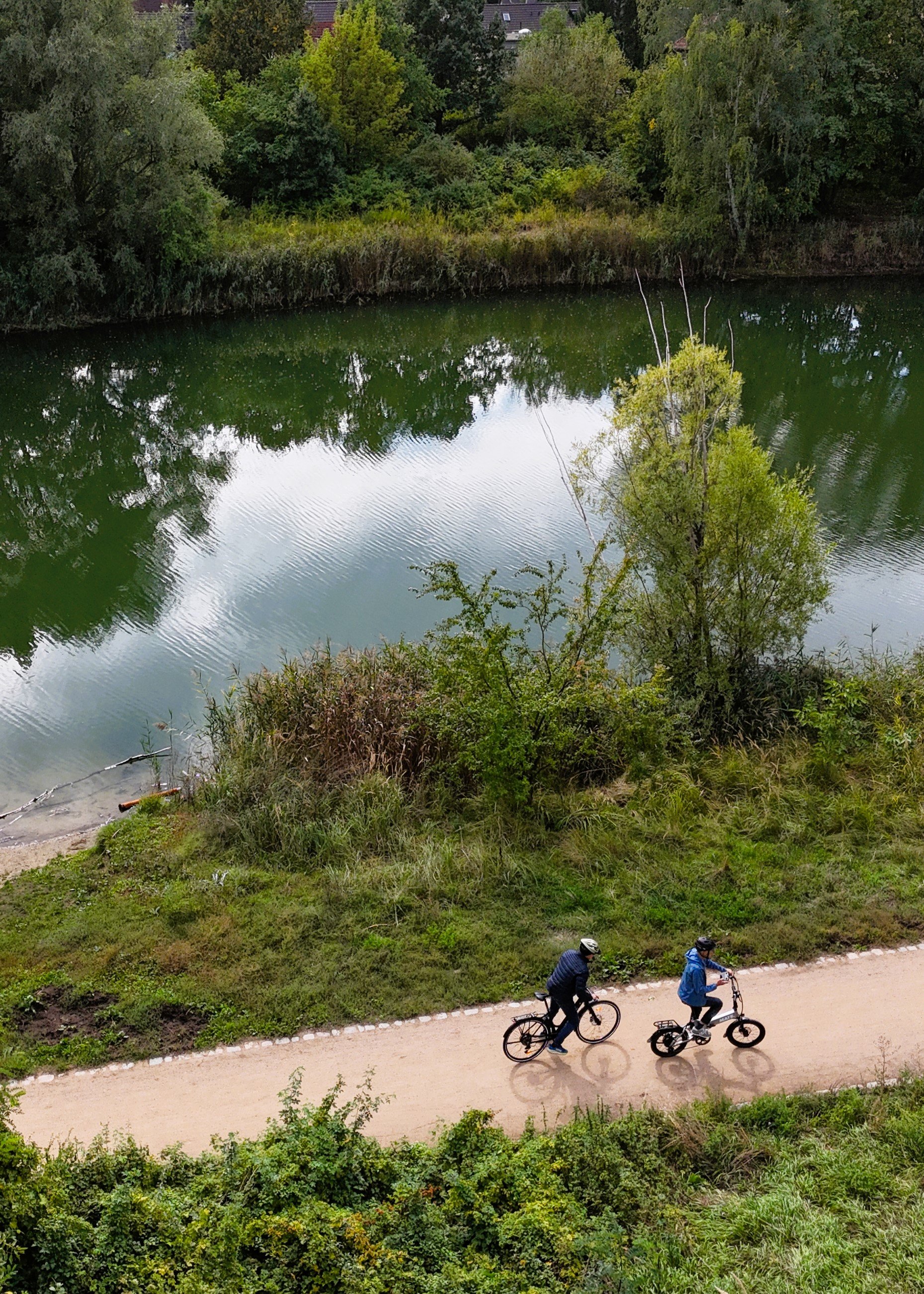 E-Bike-Test, zwei Männer auf Fahrrädern vor einem See von oben fotografiert