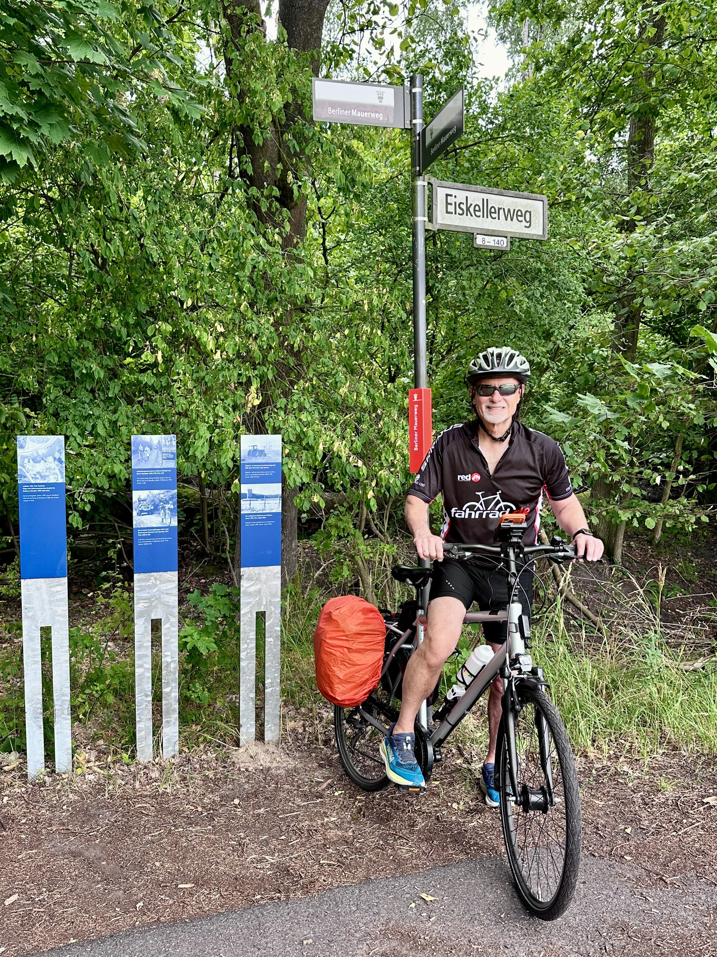 Berliner Mauerweg mit dem Fahrrad, Mann auf Fahrrad an Mauerweg-Stelen