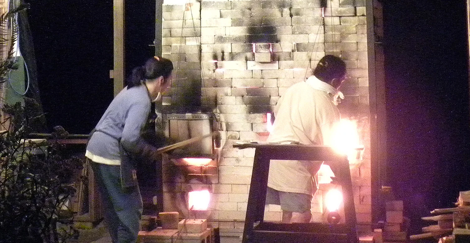 Stoking the kiln with wood