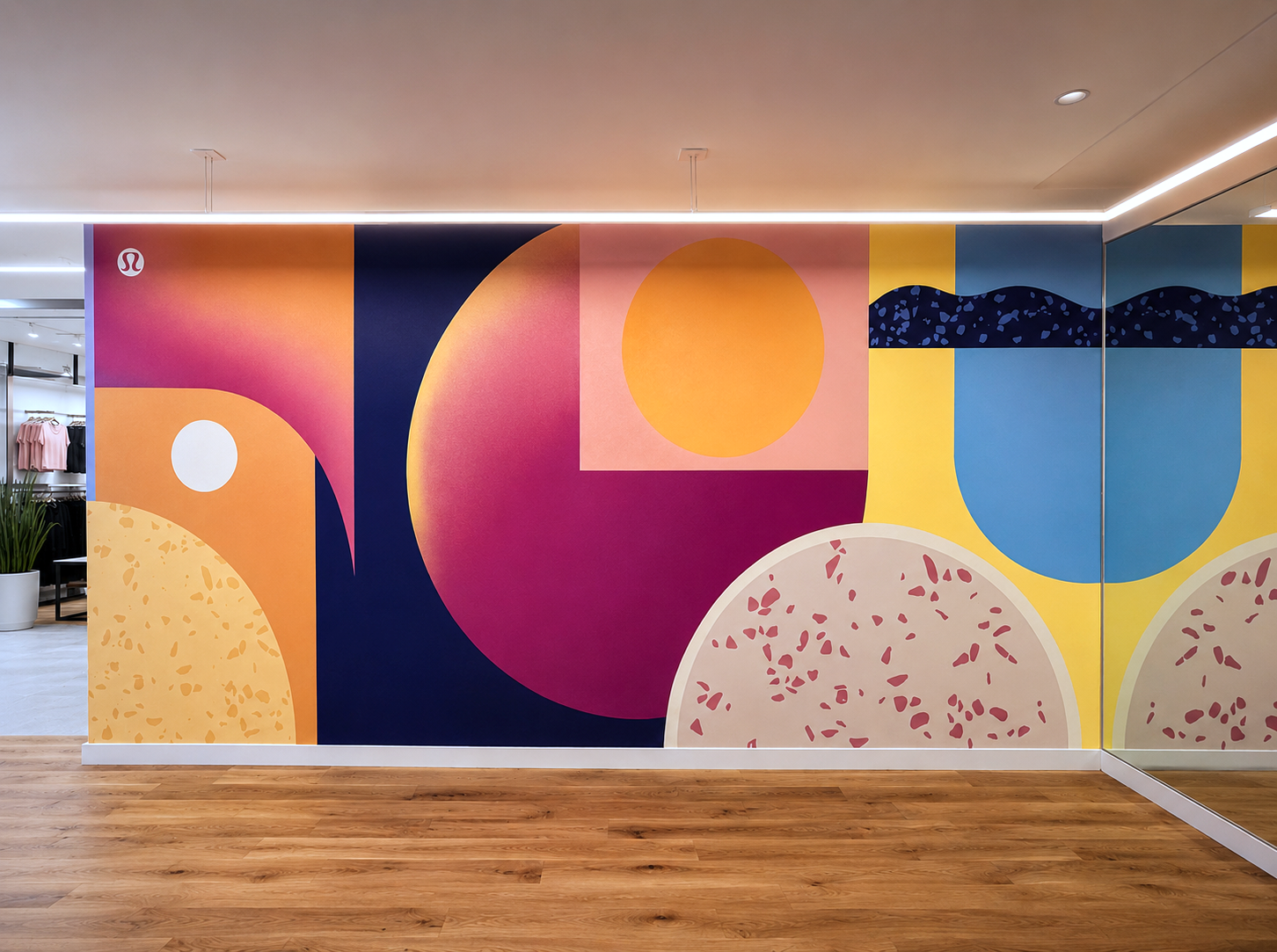 Colorful abstract mural with geometric shapes and patterns on a wall in an indoor space.