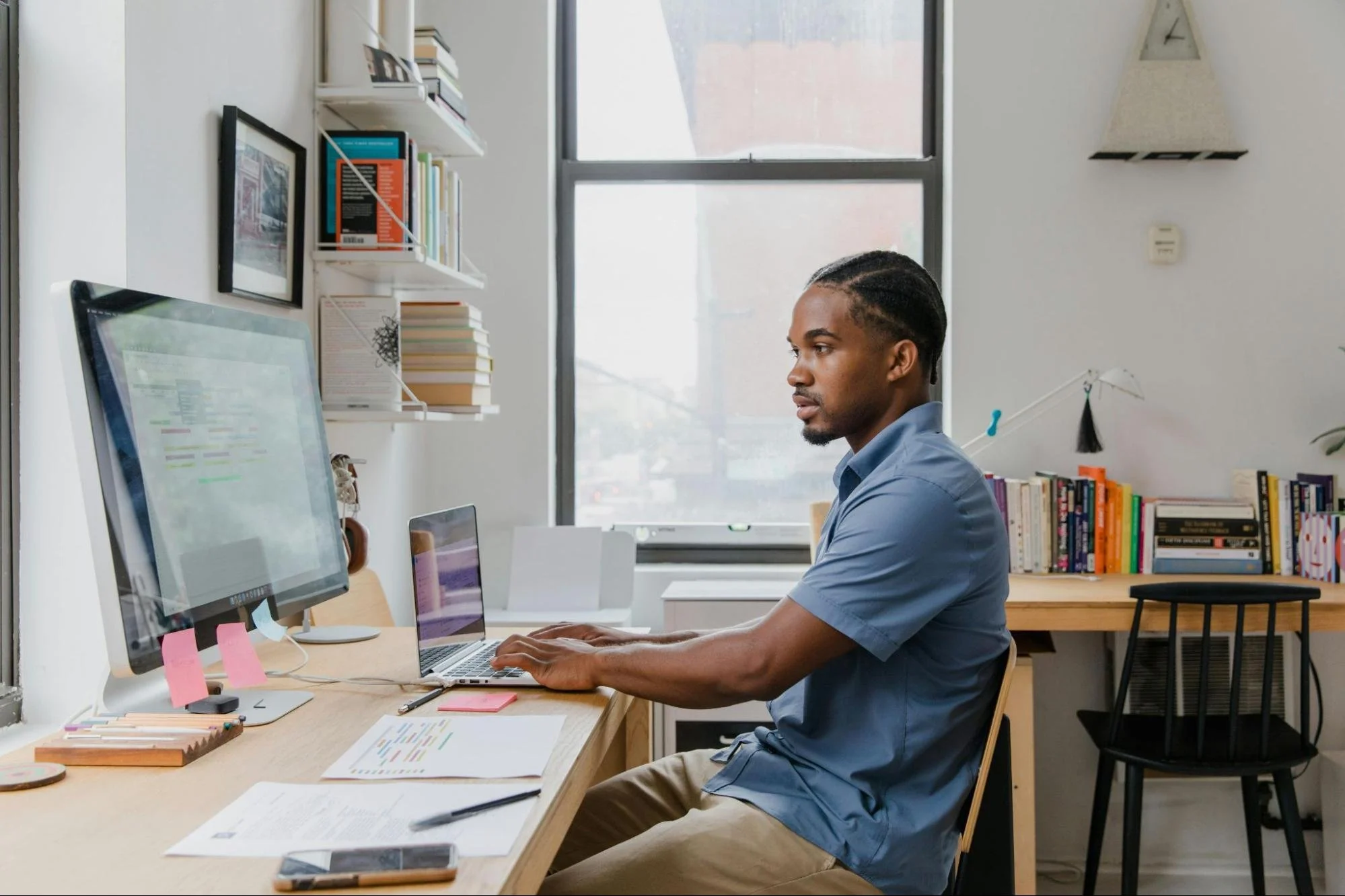 Man wearing blue shirt working at computer