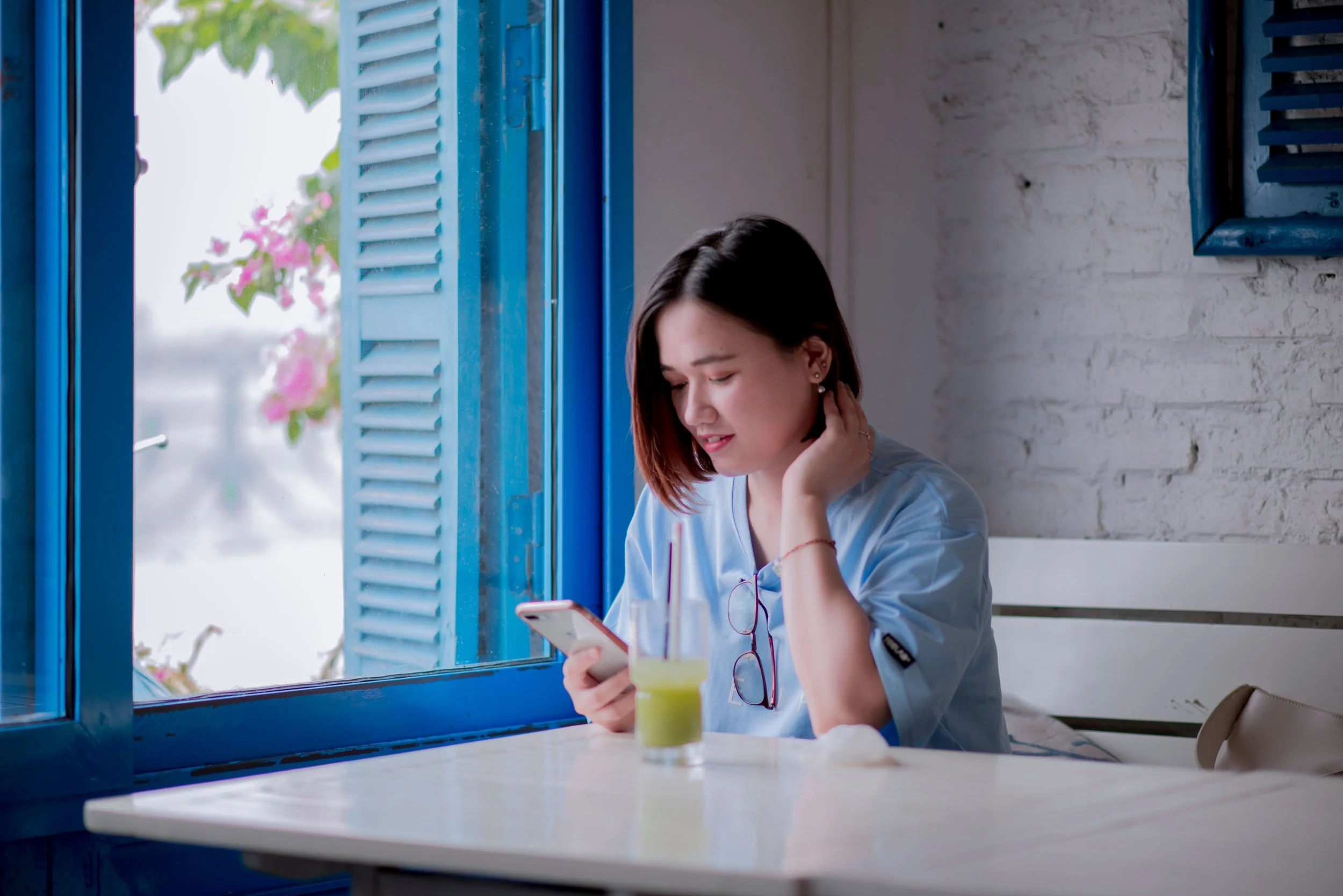 Woman sitting looking at cell phone in cafe.