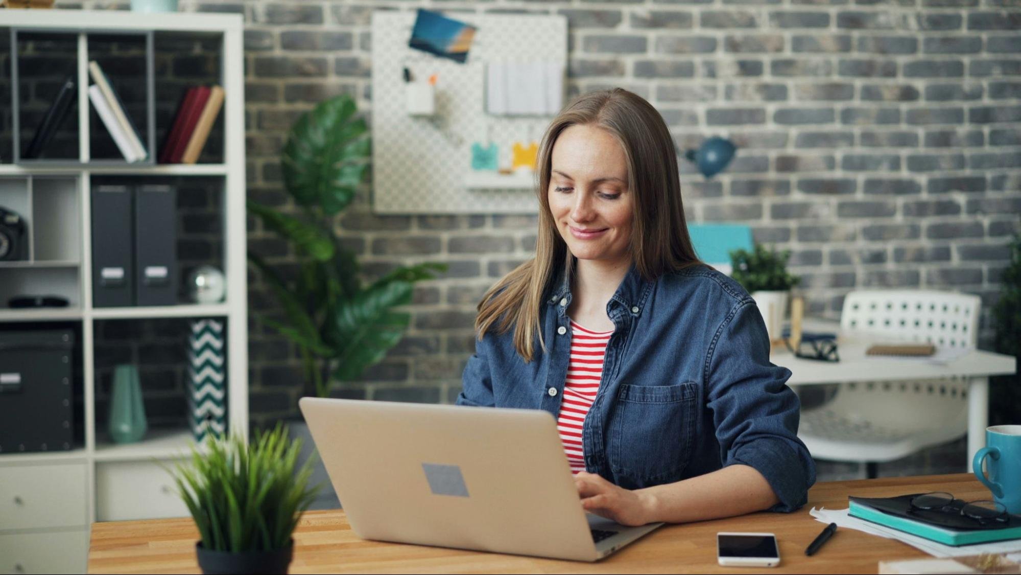 Woman looking at computer smiling working on her finances