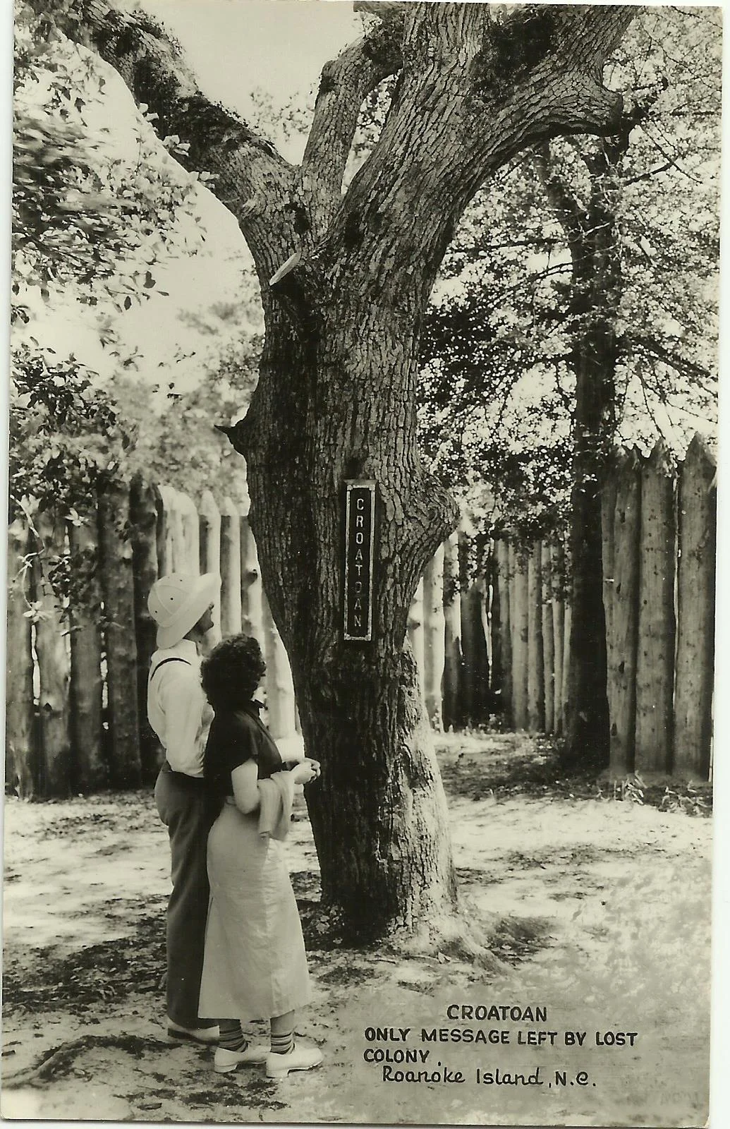 A couple gazes at the only evidence left behind at the deserted Roanoke Colony, “Croatoan.”
