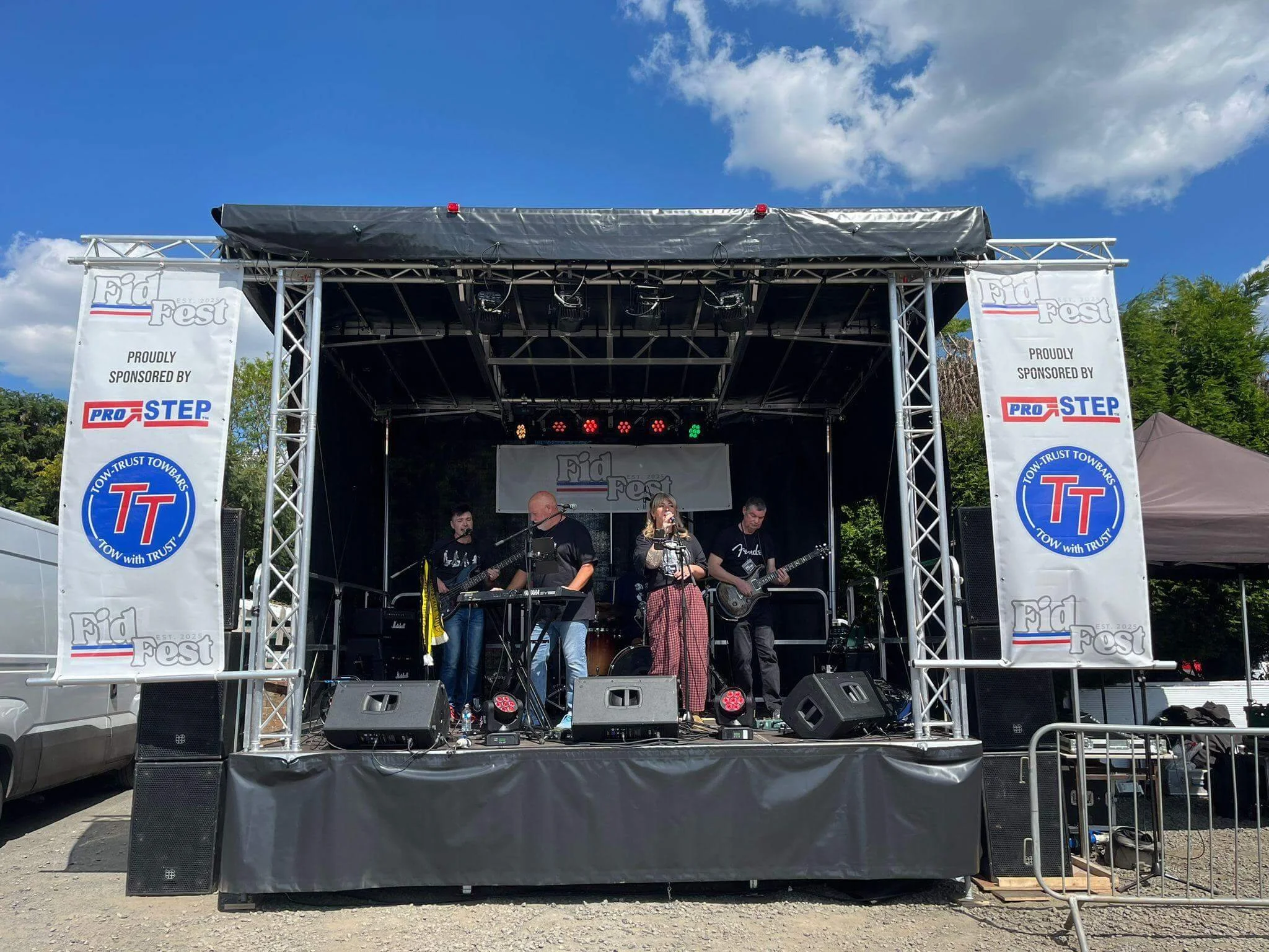 Mobile trailer stage hire with live band performing outdoors at Fid Fest event