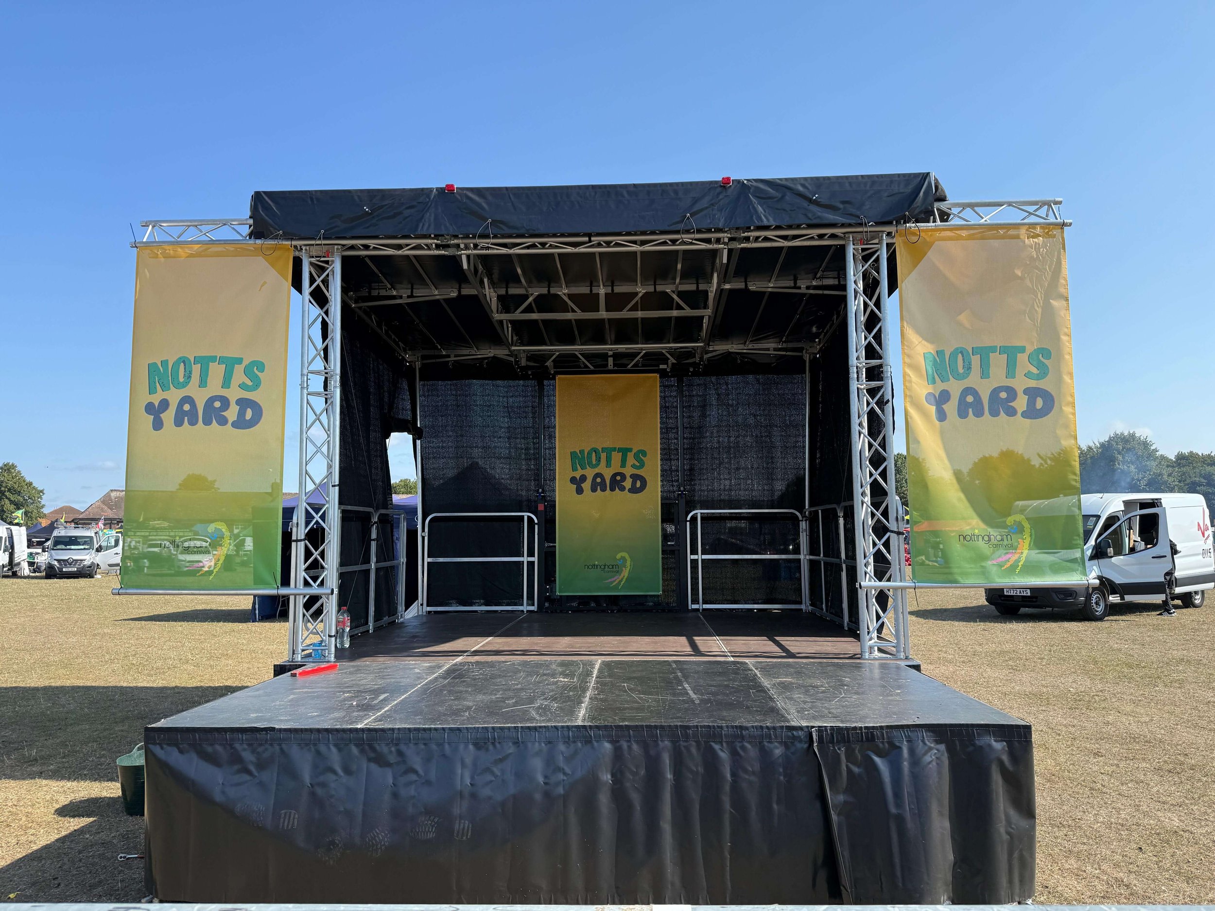 Front-facing view of outdoor festival stage structure with Notts Yard banner branding