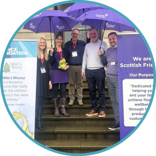 5 people are standing on the front steps of a building holding purple umbrellas that say Scottish Friendly. They are happy and smiling.
